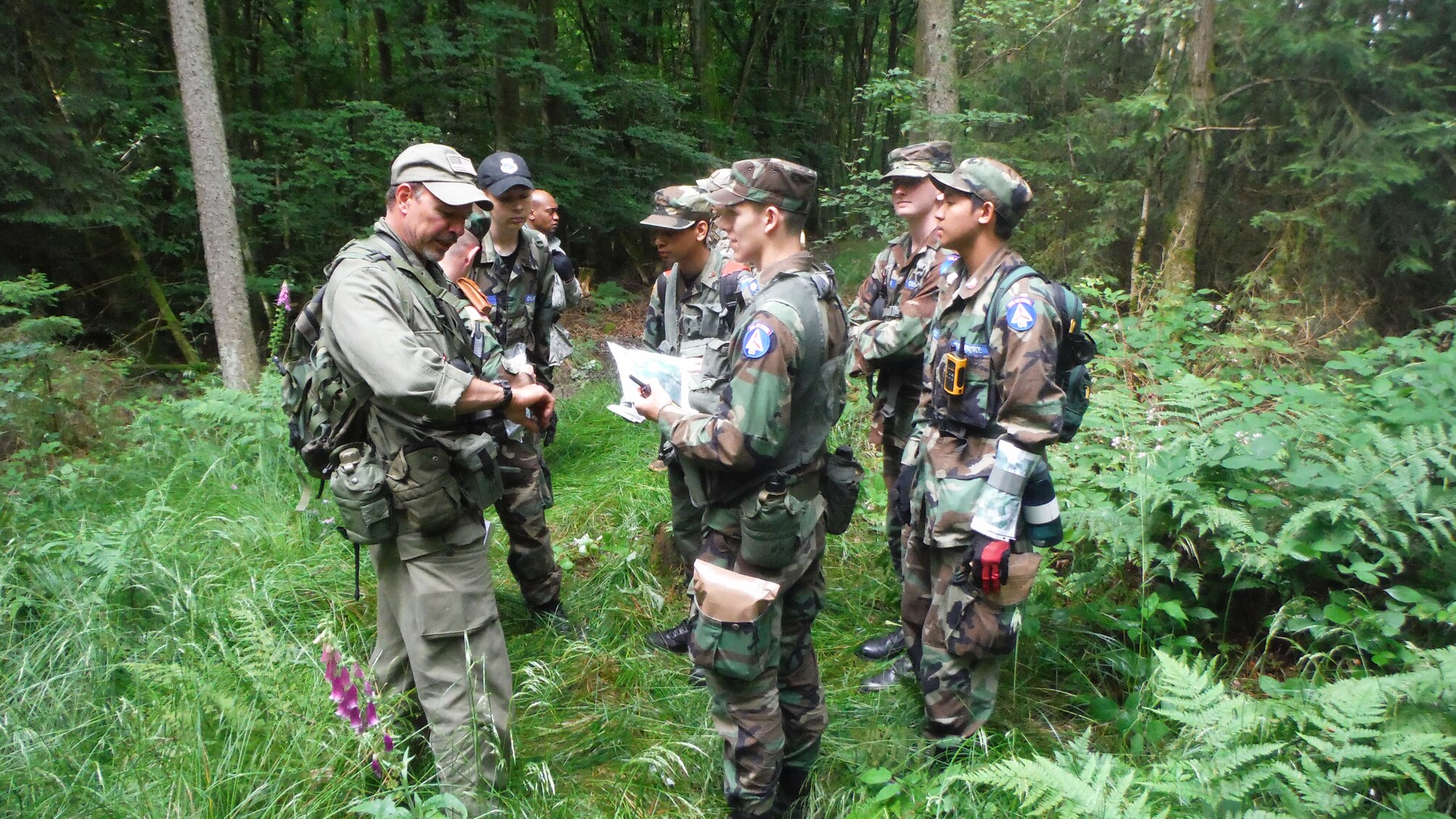 Civil Air Patrol Lt. Patrick Murphy, a senior CAP leader, tests the cadets July 6, 2014, about their current coordinates during an exercise in Luxembourg. The cadets were required to consult a map during the land navigation portion, and the CAP leaders expected the cadets to be able to search for a missing person while knowing their own location. (U.S. Air Force courtesy photo/Released)