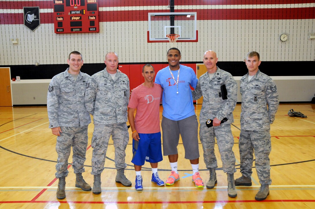 (Left to Right) Tech Sgt. Christopher Elliott, Staff Sgt. Daniel Jung, Staff Sgt. Brandon Skabla, Nate Miller, Lt. Col. Bernard Willis and Staff Sgt. Travis Higgins pose for a photo at Hayward Middle School in Springfield, Ohio, July 17, 2014. Miller, a Springfield native, and professional basketball player overseas, hosted a basketball camp where five 178th Security Forces Airmen volunteered time to speak to children about making good decisions in life. (Photo by Senior Master Sgt. Joseph Stahl/Released)