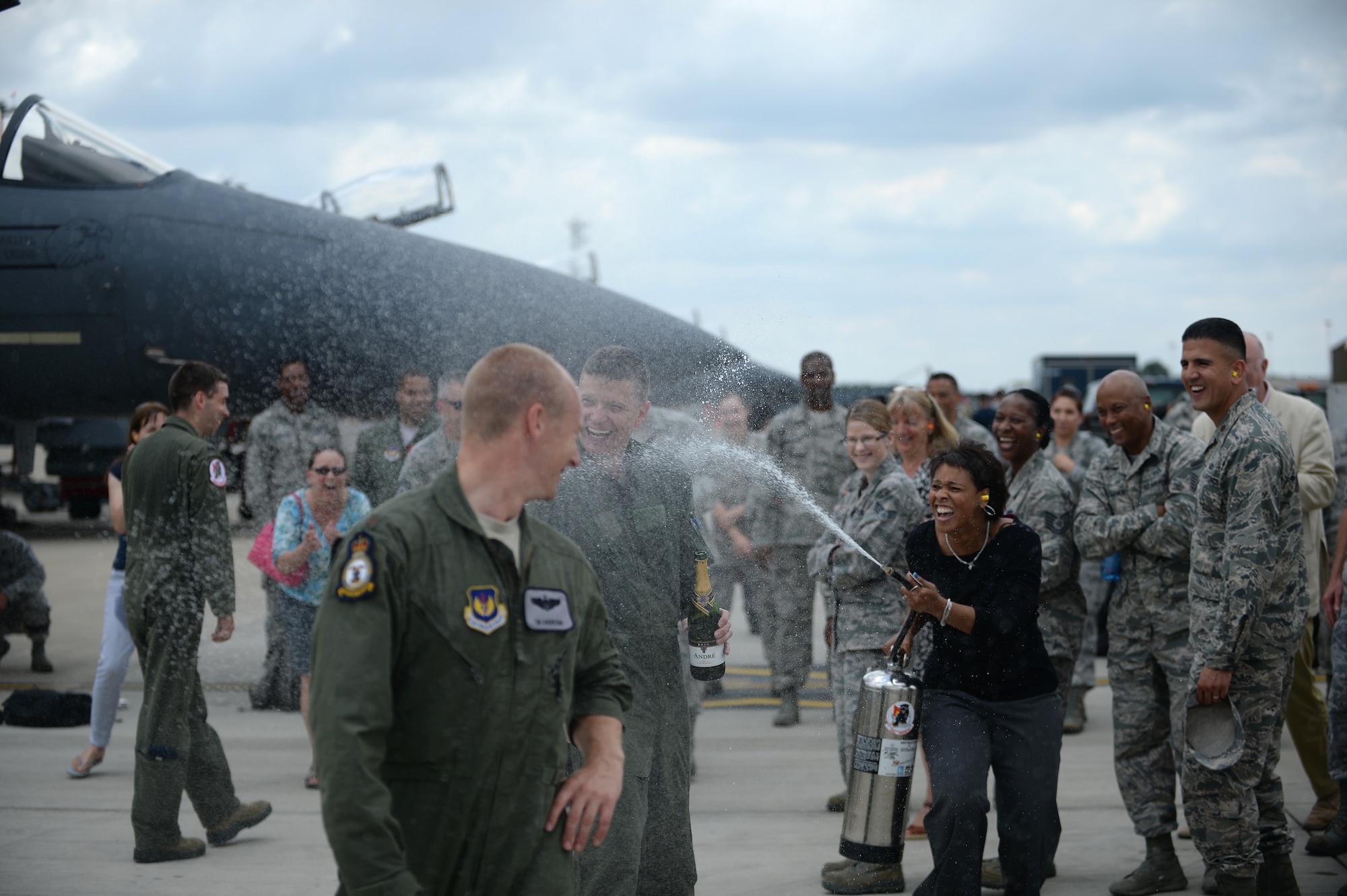 Deriska Duplechain, the 48th Fighter Wing commander’s secretary, sprays Col. Kyle Robinson, 48th FW commander, after he completed his final flight at Royal Air Force Lakenheath, England, July 17, 2014. As the 48th FW commander, Robinson has ensured the base remains Forward, Ready, Now, to provide worldwide responsive combat airpower and support when needed. (U.S. Air Force photo by Staff Sgt. Emerson Nuñez/Released)