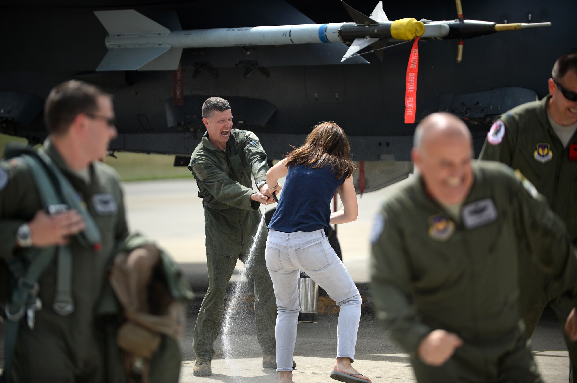 Maureen Robinson attempts to spray her husband, Col. Kyle Robinson, 48th Fighter Wing commander, after he completed his final flight at Royal Air Force Lakenheath, England, July 17, 2014. After serving as the 48th FW commander for more than two years, Robinson has been assigned to the Pentagon. (U.S. Air Force photo by Staff Sgt. Emerson Nuñez/Released)