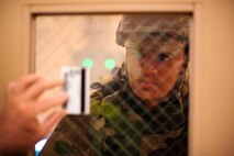 Senior Airman Brenai Smith, 8th Civil Engineer Squadron shelter management team augmentee, checks an Airman’s identification card before letting them into the building during exercise Beverly Midnight 14-2 at Kunsan Air Base, Republic of Korea, July 18, 2014. The Operational Readiness Exercise assesses mission capabilities and ensures the Wolf Pack is in a constant state of readiness. (U.S. Air Force photo by Senior Airman Taylor Curry/Released)