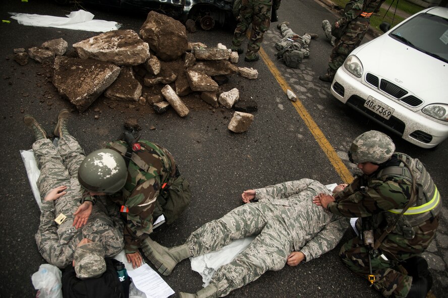 Emergency responders assist simulated mortar attack victims during exercise Beverly Midnight 14-2 at Kunsan Air Base, Republic of Korea, July 17, 2014. The Operational Readiness Exercise assesses mission capabilities and ensures the Wolf Pack is in a constant state of readiness. (U.S. Air Force photo by Senior Airman Taylor Curry/Released) 