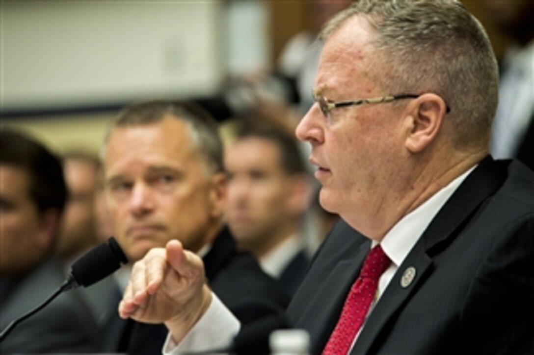 Deputy Defense Secretary Bob Work testifies on the fiscal year 2015 budget request for overseas contingency operations as Navy Adm. James A. Winnefeld Jr., vice chairman of the Joint Chiefs of Staff, looks on before the House Armed Services Committee in Washington, D.C., July 16, 2014. 