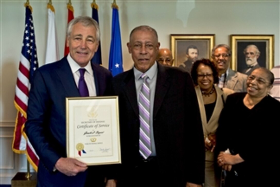 Defense Secretary Chuck Hagel presents a Certificate of Service to Gerald Bryant for 55 years of federal service during an award ceremony at the Pentagon, July 18, 2014.
