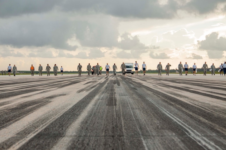 Members of the 482nd Fighter Wing line perform a foreign object damage walk as part of Wingman Day July 12, 2014, on Homestead Air Reserve Base, Fla. A FOD walk is conducted to remove potentially dangerous debris from the flightline and prevent damage to aircraft fuselage and engines. (U.S. Air Force photo/Senior Airman Jaimi L. Upthegrove)