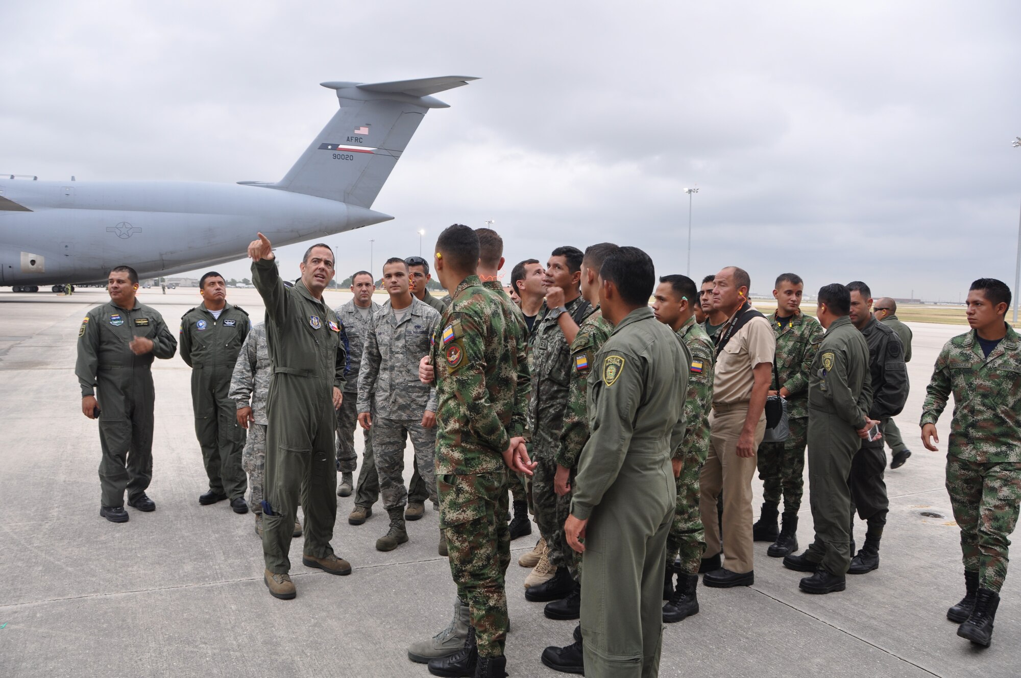 Staff Sgt. Joseph Cannella, loadmaster, 68th Airlift Squadron, Joint Base San Antonio-Lackland with students from the Inter-American Air Forces Academy, JBSA-Lackland stand on the flight line just prior to boarding one of the 443rd Airlift Wing’s C-5A Galaxies. The students had an opportunity to receive a tour of a C-5A static, the wing's propulsion branch, the metals technology and structural repair shops, and how the “Alamo Wing” maintainer’s keep their C5As mission ready, July 17, 2014. The tour was hosted by the 433rd Airlift Wing, JBSA-Lackland, Texas. (U.S. Air Force photo by Captain Cris Medina)