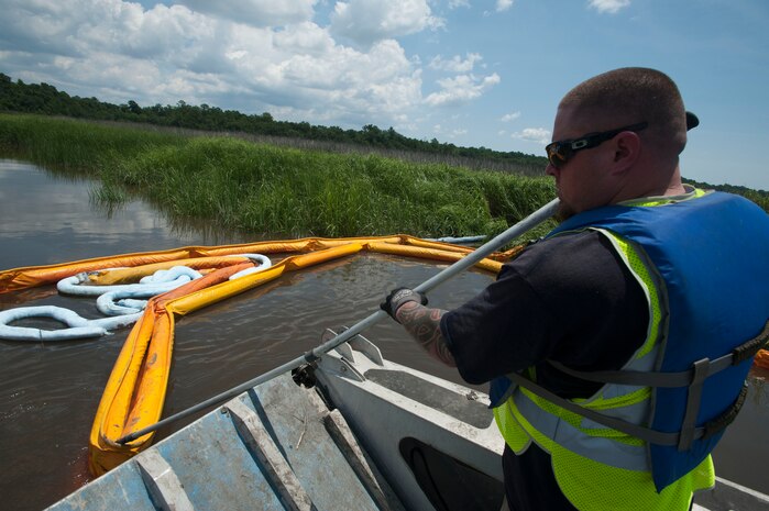 JOINT BASE CHARLESTON, S.C. -  A member of a cleanup crew adjusts a tool called a “boom,” to collect jet fuel at a cleanup site where a drainage ditch enters the Ashley River July 18, 2014. Officials estimate that 1,200 gallons of fuel escaped from the Joint Base Charleston – Air Base flightline during a leak July 16. An inspection of the Ashley River boom July 19 revealed no further fuel collection or pooling. (U.S. Air Force photo/Staff Sgt. William O'Brien)