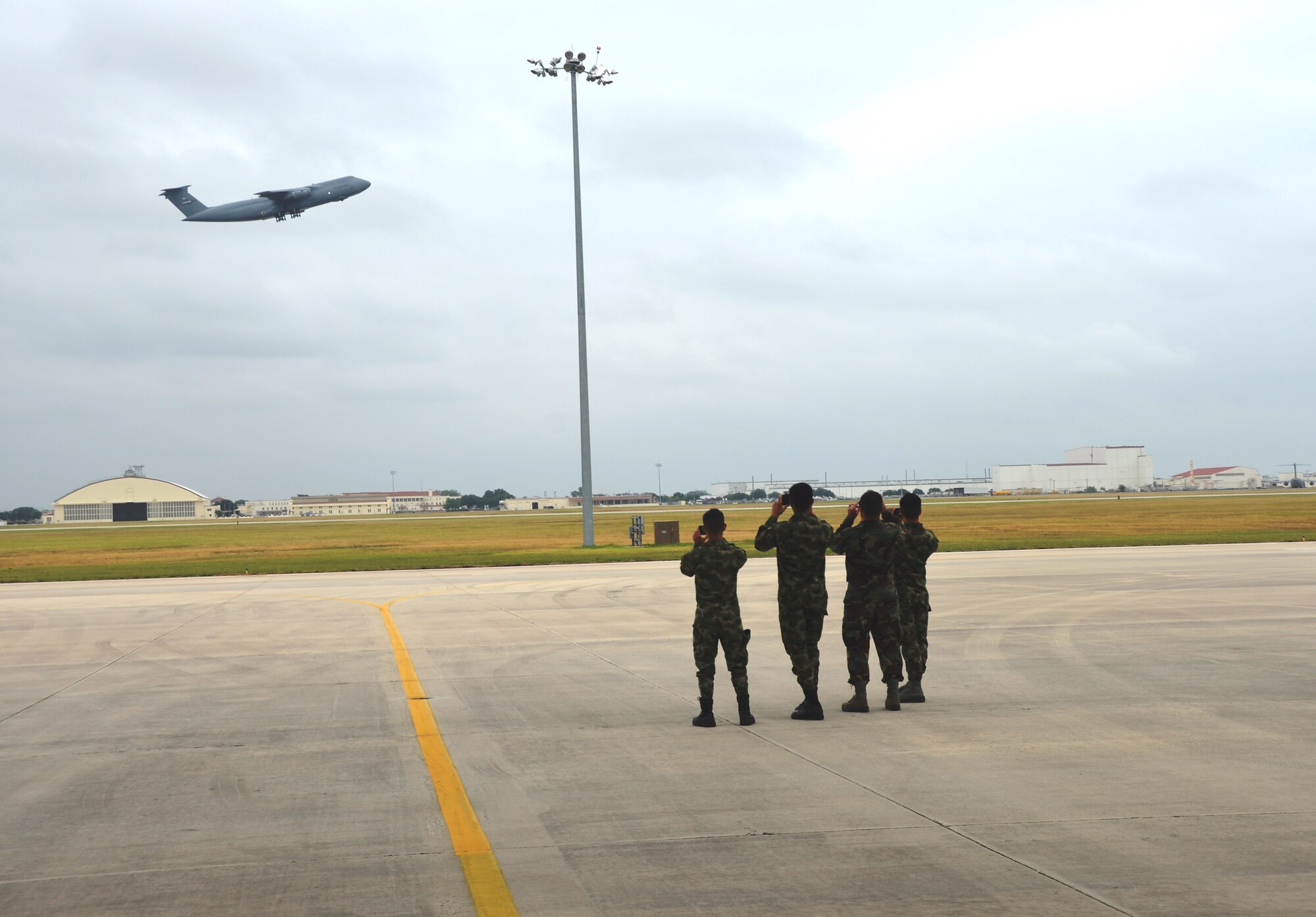 Students from the Inter-American Air Forces Academy, Joint Base San Antonio -Lackland, Texas watch as a massive C-5A Galaxy from the 433rd Airlift Wing take off from JBSA–Lackland, Texas. July 17, 2014.  IAAFA students had an opportunity to receive a tour of a C-5A static, the wing's propulsion branch, the metals technology and structural repair shops, and how the “Alamo Wing” maintainer’s keep their C5As mission ready, July 17, 2014. The tour was hosted by the 433rd Airlift Wing, JBSA-Lackland, Texas. (U.S. Air Force photo by Minnie Jones)


