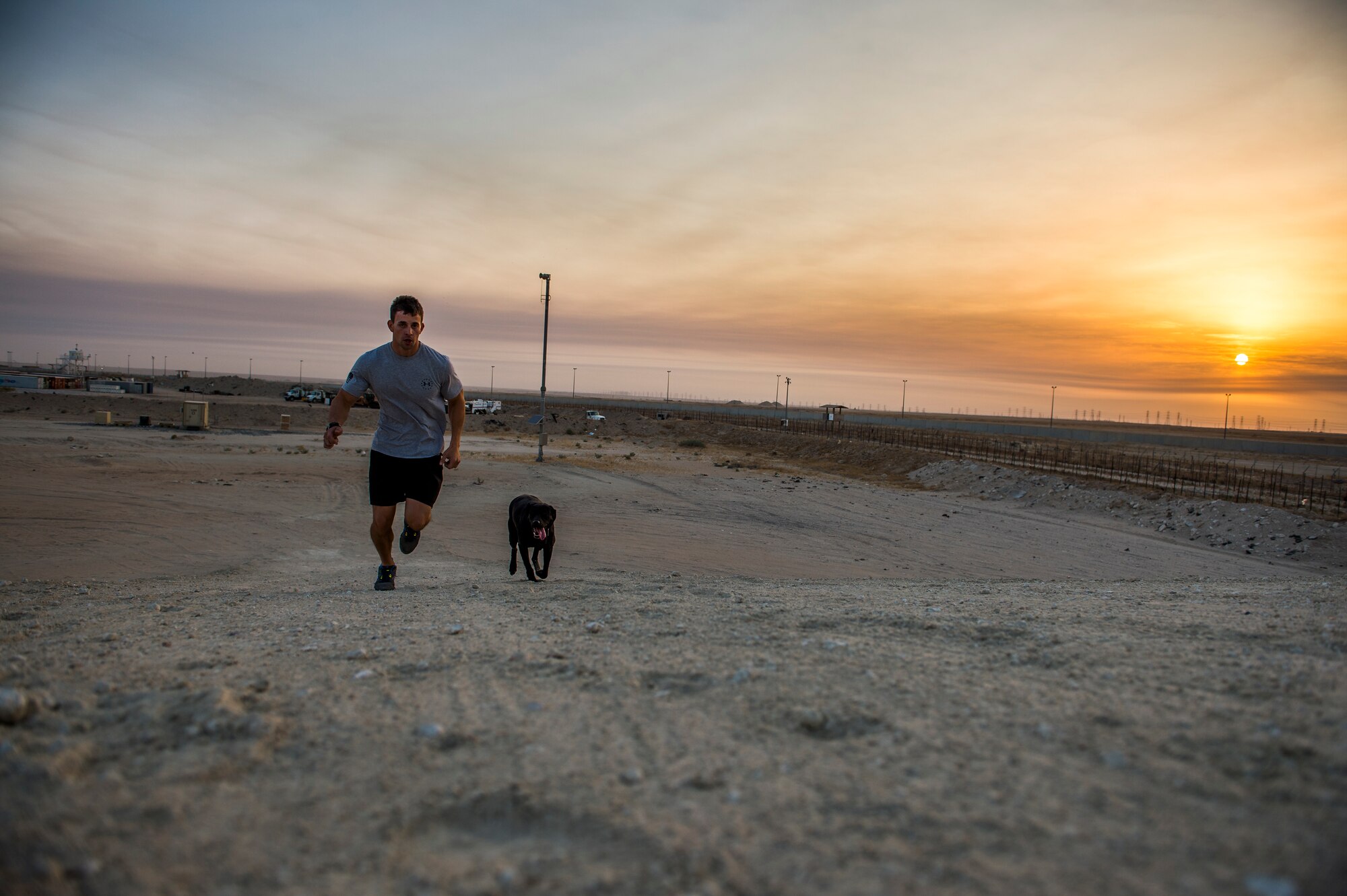 U.S Air Force Staff Sgt. Jesse Galvan, 386th Expeditionary Security Forces Squadron military working dog handler, runs in the early morning with his dog, Ritz, July 19, 2014 at an undisclosed location in Southwest Asia. Galvan has been partnered with Ritz for two and a half years and deployed twice with her. The Dallas-Ft. Worth native deployed here from Tinker Air Force Base, Oklahoma in support of Operation Enduring Freedom. (U.S. Air Force photo by Staff Sgt. Jeremy Bowcock)