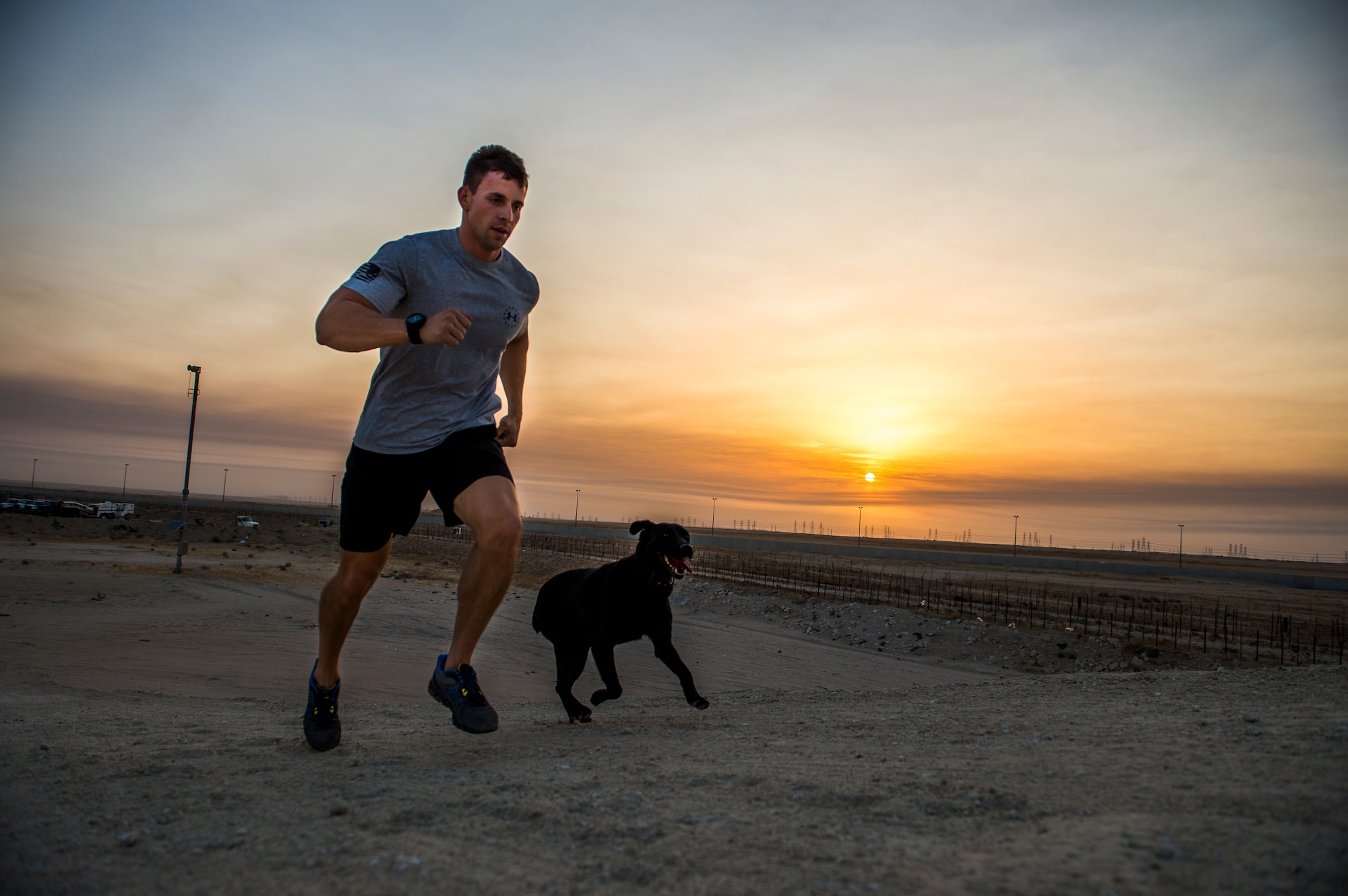 U.S Air Force Staff Sgt. Jesse Galvan, 386th Expeditionary Security Forces Squadron military working dog handler, runs in the early morning with his dog, Ritz, July 19, 2014 at an undisclosed location in Southwest Asia. Galvan has been partnered with Ritz for two and a half years and deployed twice with her. The Dallas-Ft. Worth native deployed here from Tinker Air Force Base, Oklahoma in support of Operation Enduring Freedom. (U.S. Air Force photo by Staff Sgt. Jeremy Bowcock)