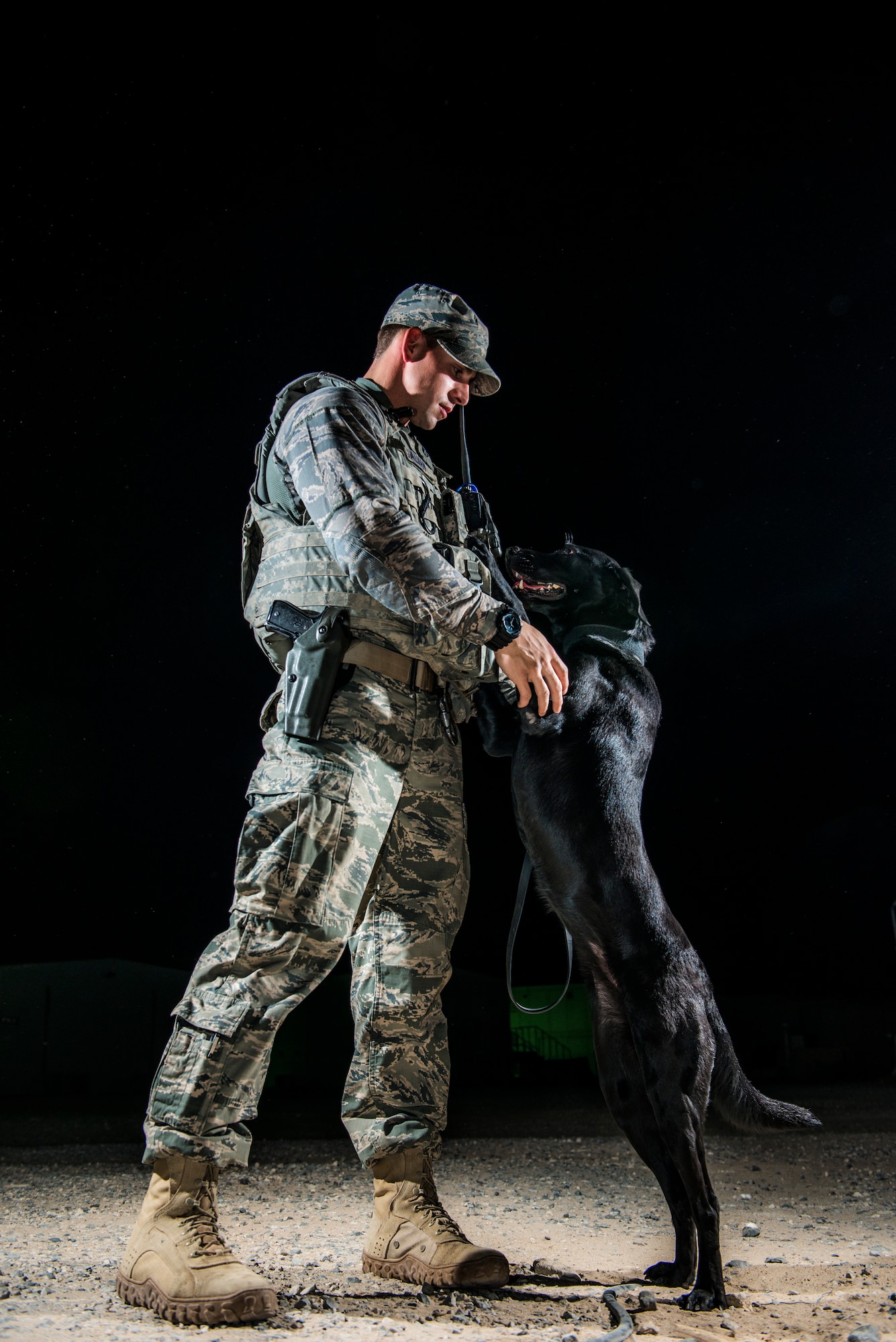 U.S Air Force Staff Sgt. Jesse Galvan, 386th Expeditionary Security Forces Squadron military working dog handler, poses with his dog, Ritz, July 16, 2014 at an undisclosed location in Southwest Asia. Galvan has been partnered with Ritz for two and a half years and deployed twice with her. The Dallas-Ft. Worth native deployed here from Tinker Air Force Base, Oklahoma in support of Operation Enduring Freedom. (U.S. Air Force photo by Staff Sgt. Jeremy Bowcock)
