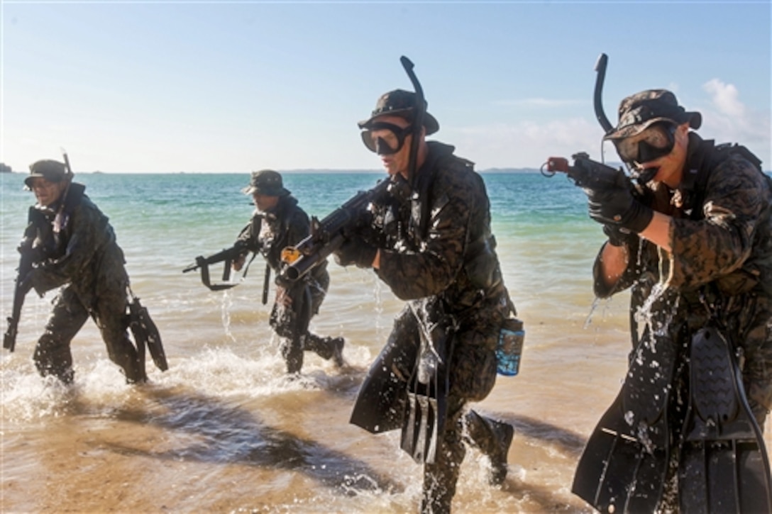 U.S. Marines and Japanese Ground Self-Defense Force soldiers run as they emerge from the water while practicing small-unit techniques as part of the Japan Observer Exchange Program at Kin Blue Beach, Okinawa, Japan, July 16, 2014. The Marines are assigned to Lima Company, Battalion Landing Team 3rd Battalion, 5th Marine Regiment, 31st Marine Expeditionary Unit. The program enhances the interoperability of the two forces and the region's security. 