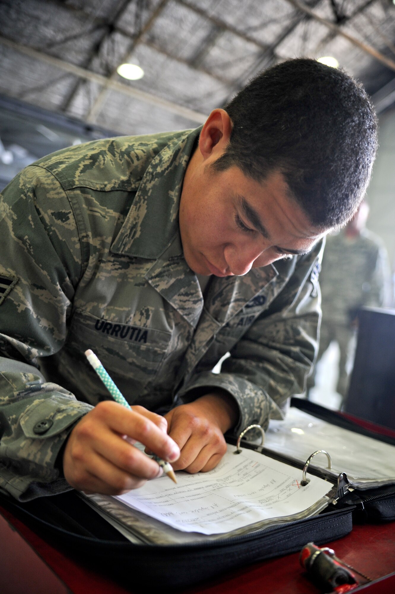 Senior Airman Juan Urrutia, 36th Aircraft Maintenance Unit weapons load crew member, reads over a check list during a quarterly load crew competition on Osan Air Base, Republic of Korea, July 18, 2014. Load crew members are evaluated on their safety, speed, and use of the checklist. (U.S. Air Force photo/Senior Airman Matthew Lancaster)