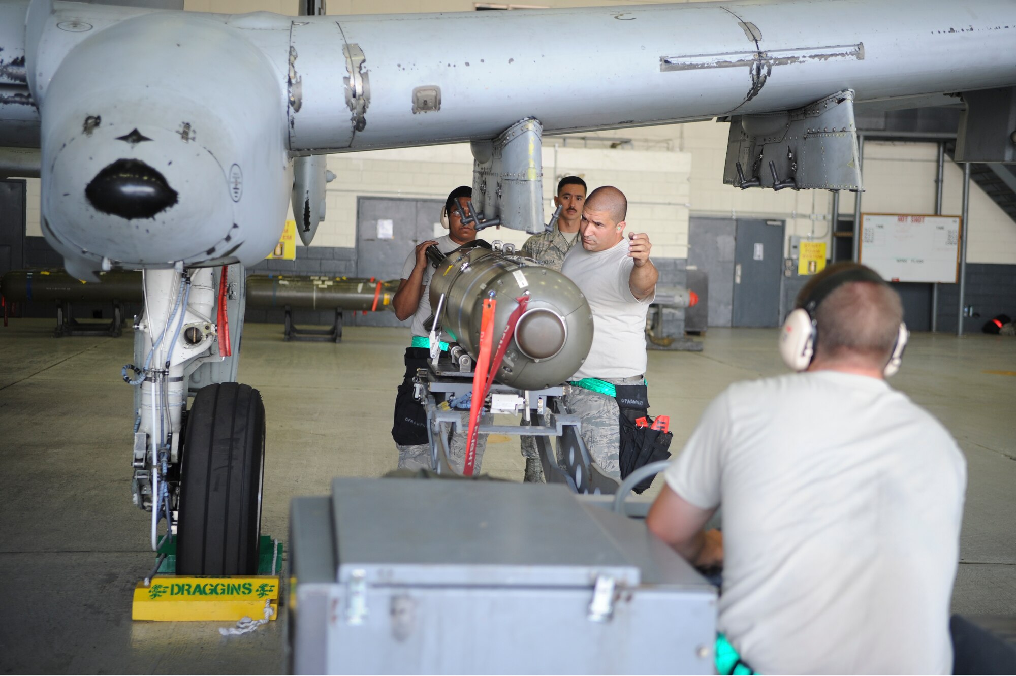 The 25th Aircraft Maintenance Unit weapons load crew team loads a bomb onto an A-10 Thunderbolt II during a quarterly load crew competition on Osan Air Base, Republic of Korea, July 18, 2014. Evaluators inspected two teams as they loaded munitions. (U.S. Air Force photo/Senior Airman Matthew Lancaster)