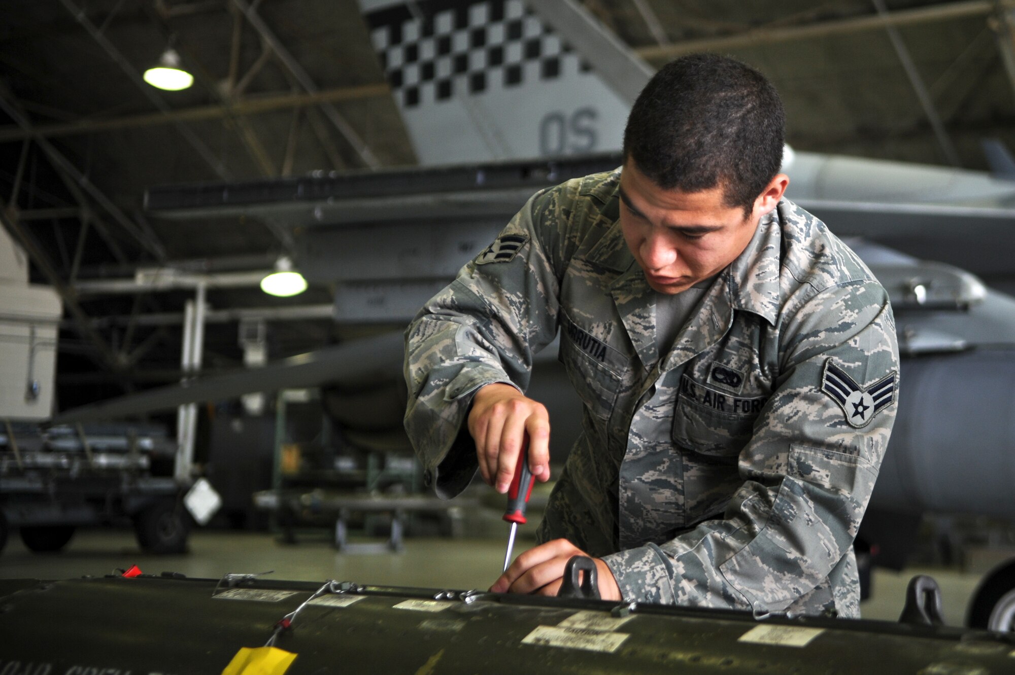 Senior Airman Juan Urrutia, 36th Aircraft Maintenance Unit weapons load crew member, prepares a bomb to be loaded onto an F-16 Fighting Falcon during a quarterly load crew competition on Osan Air Base, Republic of Korea, July 18, 2014. Load crew competitions promote a safe competitive environment where Airmen display their skills and ability to apply their training. (U.S. Air Force photo/Senior Airman Matthew Lancaster)