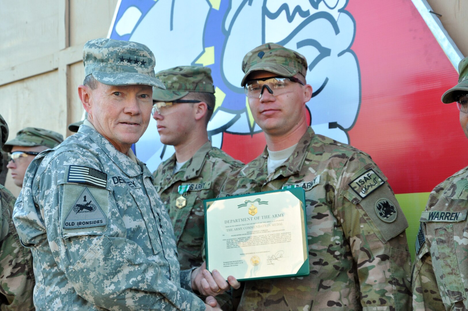 Army Gen. Martin Dempsey, the 18th Chairman of the Joint Chiefs of Staff, poses with Georgia Army National Guard Spc. Robert Schrader after presenting Schrader with an Army Commendation Medal Feb. 10, 2012 at Forward Operating Base Shank, Afghanistan. Schrader received the award for his actions following a vehicle born improvised explosive device attack on Command Outpost Sayed Abad September 2011.