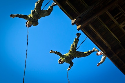 Two Canadian army soldiers from the 36th Canadian Brigade Group out of Nova Scotia, Canada, jump off the side of a rappelling tower with the
encouragement of Army Staff Sgt. Matthew T. Woyansky, an infantry air assault instructor, assigned to the Virginia National Guard's 1st Battalion, 183rd Regiment, Regional Training Institute, at Fort Pickett, Va., Feb. 21, 2012. The Canadian troops were participating in the joint-annual exercise, Southbound Trooper.