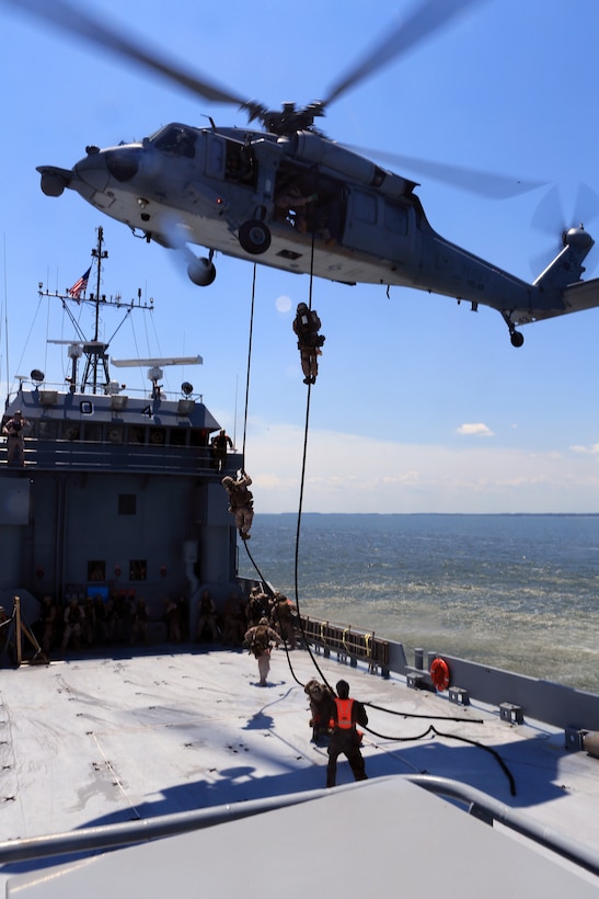 Marines with the 24th Marine Expeditionary Unit’s Maritime Raid Force fast-rope from a Navy MH-60 Seahawk, from Amphibious Squadron 8, onto a simulated merchant vessel during a Visit, Board, Search, and Seizure exercise at Joint Base Langley-Eustis, Va., July 17, 2014. The exercise was part of Realistic Urban Training, the 24th MEU’s first major pre-deployment training exercise in preparation for their deployment at the end of the year. The MRF is a contingent of Marines from Force Reconnaissance Company, 2nd Reconnaissance Battalion. (U.S. Marine Corps photo by Cpl. Devin Nichols)