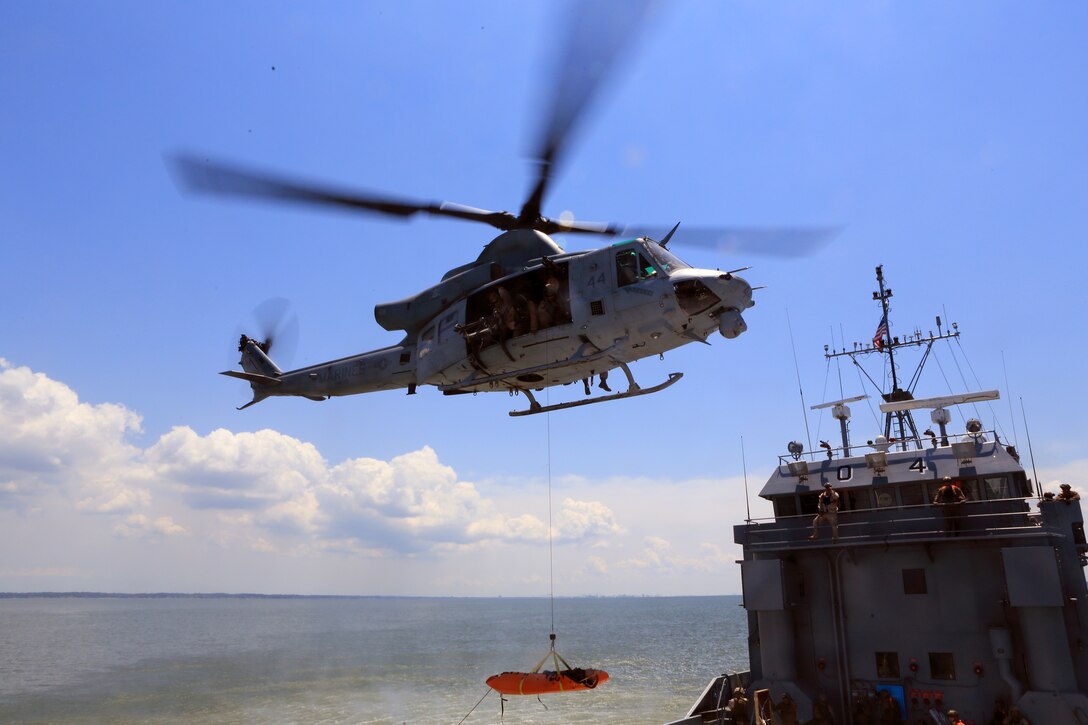 A UH-1Y Huey from the 24th Marine Expeditionary Unit’s Air Combat Element, Marine Medium Tiltrotor Squadron 365 (Reinforced), hovers over a simulated merchant vessel as a crew chief retrieves a mock casualty during a Visit, Board, Search, and Seizure exercise at Joint Base Langley-Eustis, Va., July 17, 2014. The exercise was part of Realistic Urban Training, the 24th MEU’s first major pre-deployment training exercise in preparation for their deployment at the end of the year. The Huey and crew is attached to VMM-365 (Rein) from Marine Light Attack Helicopter Squadron 269. (U.S. Marine Corps photo by Cpl. Devin Nichols)