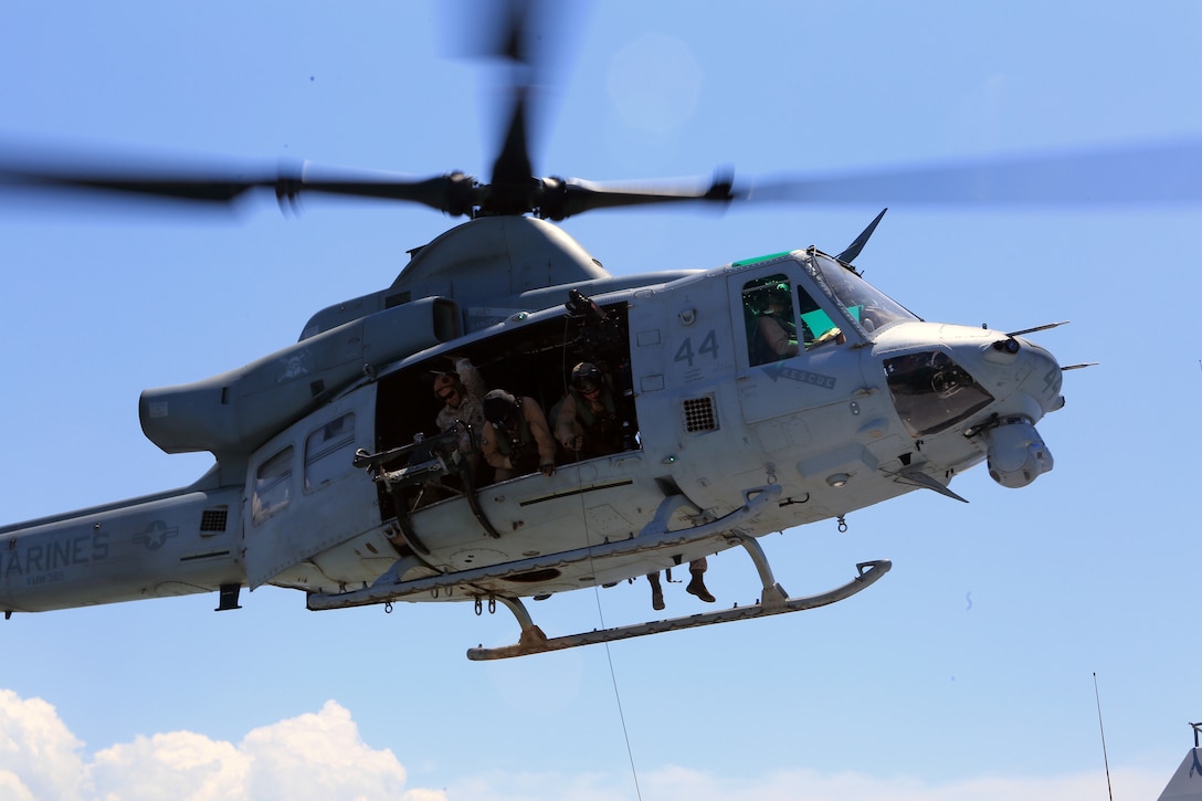 A UH-1Y Huey from the 24th Marine Expeditionary Unit’s Air Combat Element, Marine Medium Tiltrotor Squadron 365 (Reinforced), hovers over a simulated merchant vessel as a crew chief retrieves a mock casualty during a Visit, Board, Search, and Seizure exercise at Joint Base Langley-Eustis, Va., July 17, 2014. The exercise was part of Realistic Urban Training, the 24th MEU’s first major pre-deployment training exercise in preparation for their deployment at the end of the year. The Huey and crew is attached to VMM-365 (Rein) from Marine Light Attack Helicopter Squadron 269. (U.S. Marine Corps photo by Cpl. Devin Nichols)