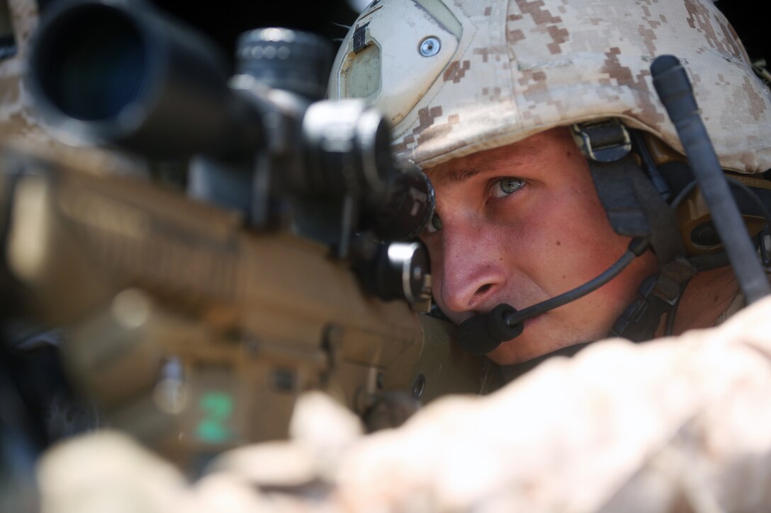 Corporal Peyton L. Simmons, a scout sniper with the 24th Marine Expeditionary Unit’s Ground Combat Element, Battalion Landing Team 3rd Battalion, 6th Marine Regiment, and Tacoma, Wash., native,  sites through an M-110 Semi-Automatic Sniper System, or SASS, during a Visit, Board, Search and Seizure exercise at Joint Base Langley-Eustis, Va., July 17, 2014. During the exercise, scout snipers used the Hueys, from Marine Medium Tiltrotor Squadron 365 (Reinforced), to provide cover for the assault force. The exercise was part of Realistic Urban Training, the first major pre-deployment training exercise for the 24th MEU in preparation for their deployment later this year. (U.S. Marine Corps photo by Lance Cpl. Dani A. Zunun) 