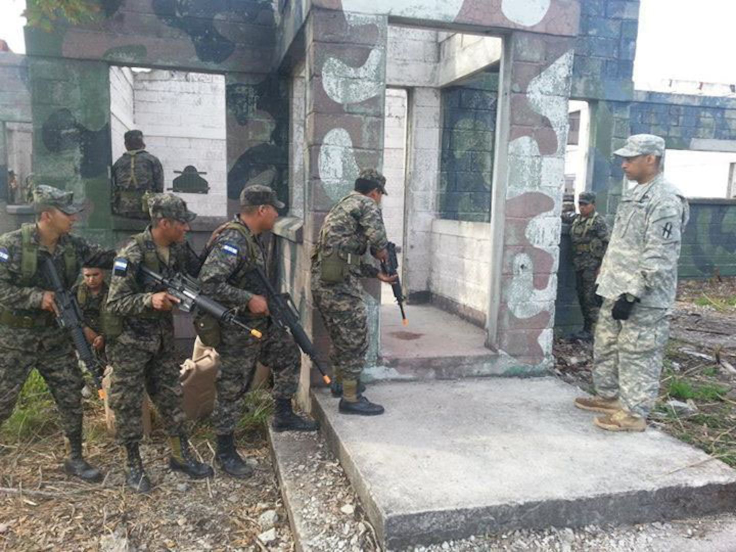 Staff Sgt. Gibran Harewood with Alpha Company, 1st Battalion, 121st Infantry Regiment of the Georgia National Guard, watches a Honduran military fire team conduct room clearing exercises in Cucuyagua, Honduras, during June of 2014. 