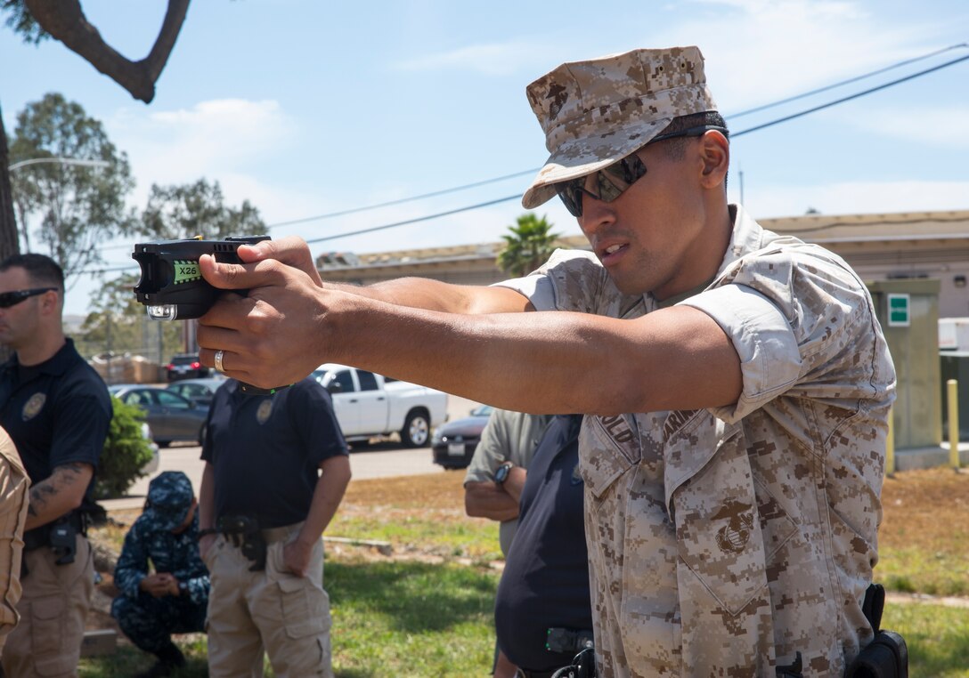 Cpl. Vettel Arnold III, a military police officer with the special reaction team aboard Marine Corps Air Station Miramar, Calif., practices aiming a Taser X26 during annual Taser training, July 18.  Police officers learned the basics of the Taser, including how to handle, inspect and reload the weapon. 