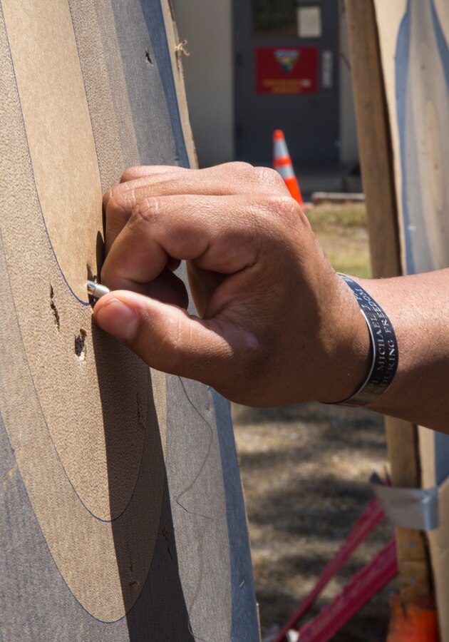 A military police officer with the Provost Marshal’s Office aboard Marine Corps Air Station Miramar, Calif., pulls a prong from a target during annual Taser training, July 18. Police officers learned the target areas at which to aim when using a Taser. 