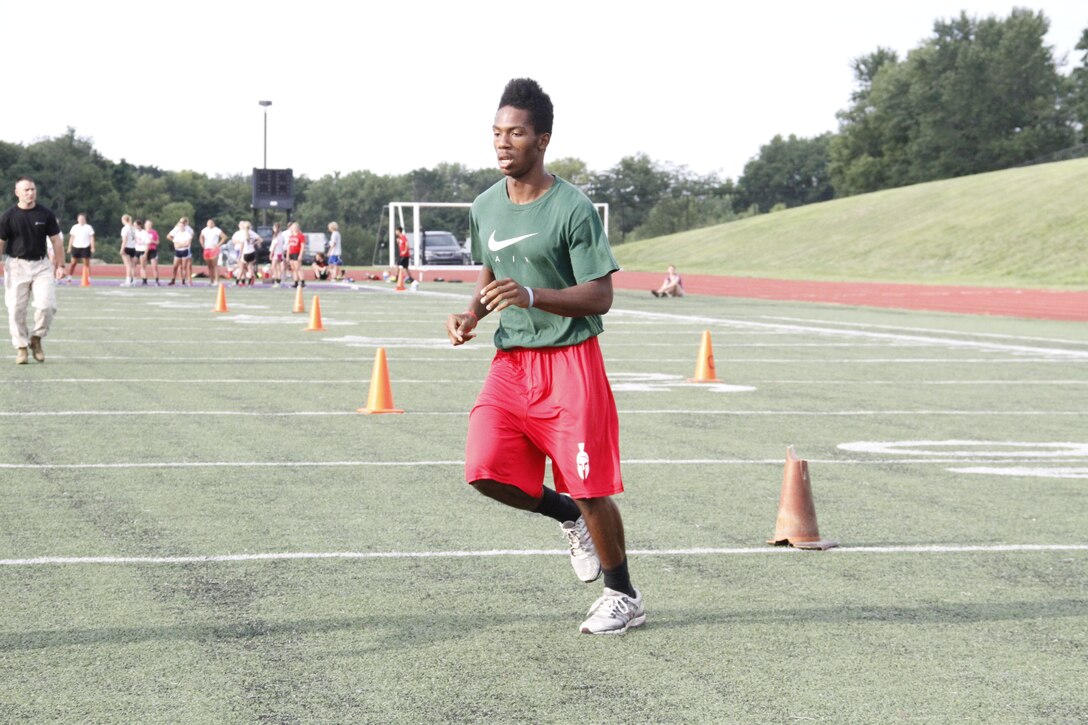 Kenyatte R. Harris, a Park Hill High School Trojans senior runningback, defensive back, and wide receiver, sprints between cones during the maneuver-under-fire portion of the Marine Corps Combat Fitness Test at the Trojans' football field July 17, 2014. Players from both the Trojan football and volleyball teams took part in the CFT. The CFT consists of an 880-meter sprint, 30-pound ammo-can lifts in two minutes, and the maneuver-under-fire.