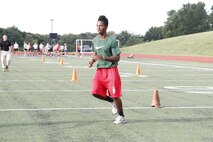 Kenyatte R. Harris, a Park Hill High School Trojans senior runningback, defensive back, and wide receiver, sprints between cones during the maneuver-under-fire portion of the Marine Corps Combat Fitness Test at the Trojans' football field July 17, 2014. Players from both the Trojan football and volleyball teams took part in the CFT. The CFT consists of an 880-meter sprint, 30-pound ammo-can lifts in two minutes, and the maneuver-under-fire.