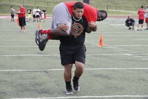 Naljay Pius, a Park Hill High School Trojans sophomore nose guard, fireman carries teammate junior Desmond A. Stirgus, a Trojans nose tackle, during the maneuver-under-fire portion of the Combat Fitness Test at the Trojans' football field July 20, 2014.  