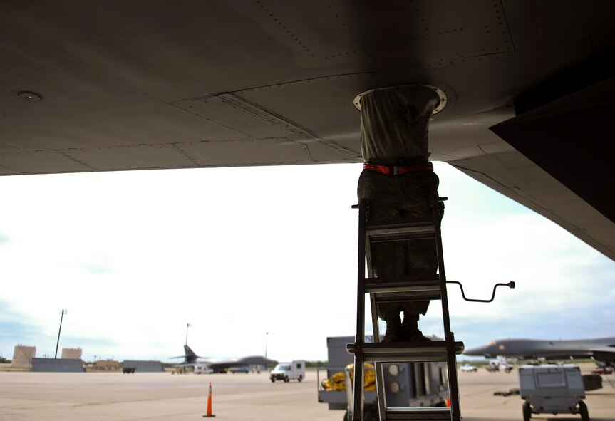 U.S. Air Force Staff Sgt. Kevin MacDonald, 7th Equipment Maintenance Squadron aerospace repair and reclamation craftsman, re-hooks torque tubes on a B-1B Lancer July 16, 2014, at Dyess Air Force Base, Texas. This step helps verify that a malfunction no longer exists after performing maintenance operations. (U.S. Air Force photo by Airman 1st Class Kedesha Pennant/Released)