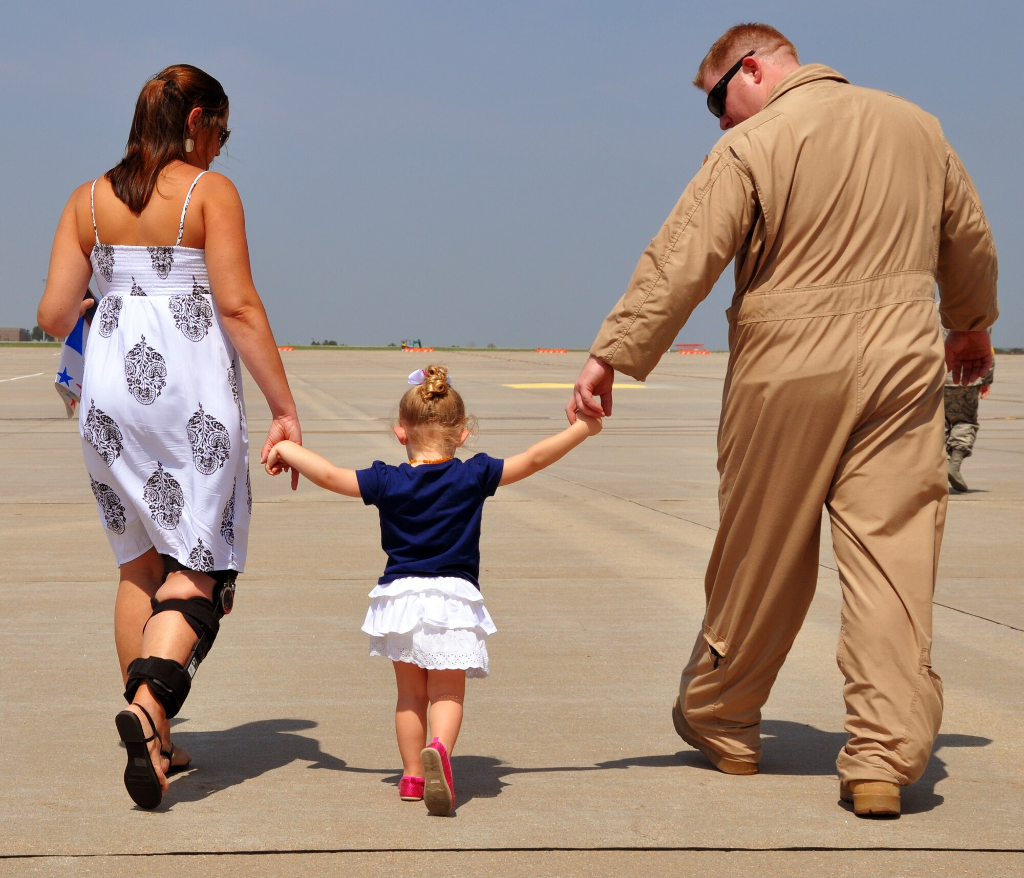 Master Sgt. Chris Norris, an air refueling boom operator assigned to the 18th Air Refueling Squadron, 931st Air Refueling Group, walks off the flightline with his wife and daughter at McConnell Air Force Base, Kan., July 21, 2014.  Norris had just returned home from a 60-day deployment to Al Udeid Air Base, Qatar, where he served as part of the 379th Air Expeditionary Wing.  (U.S. Air Force photo by Capt. Zach Anderson)