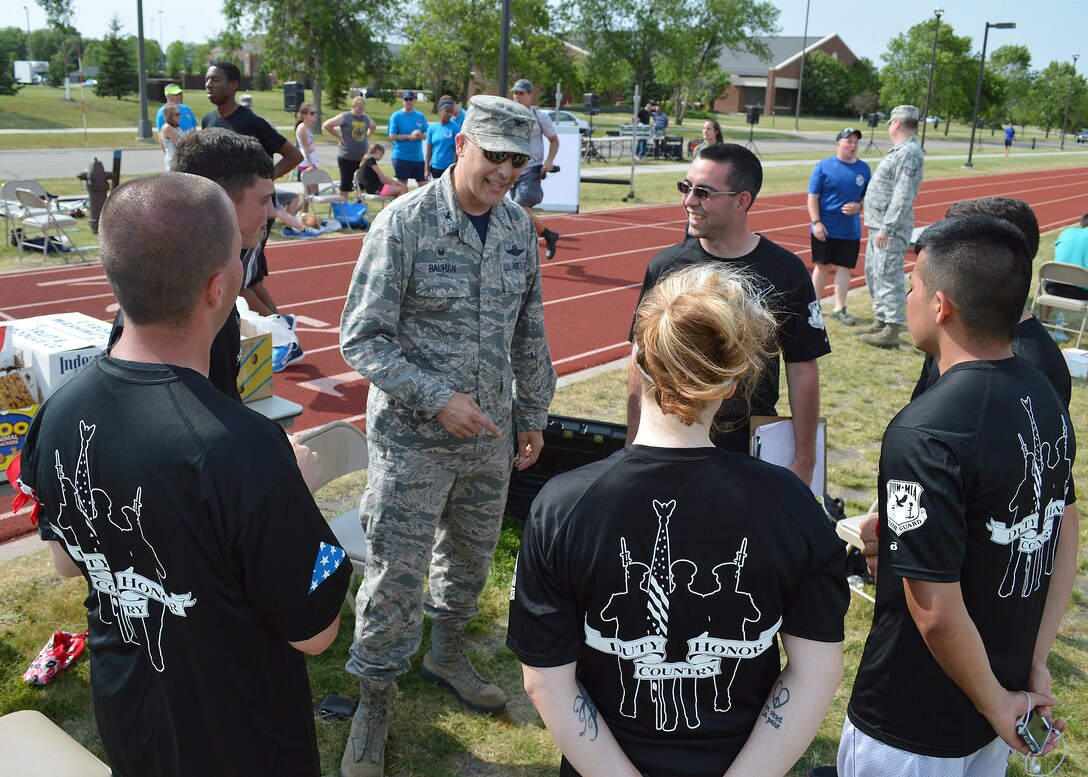 Col. Paul Bauman, 319th Air Base Wing commander, talks to members of the 319th Air Base Wing Honor Guard during the AFSA 12-Hour relay on July 18, 2014, on Grand Forks Air Force Base, N.D. “Team Awesome” from the 319th ABW HG completed 83 laps around the base outdoor running track and placed second in the event sponsored by the Air Force Sergeants’ Association, Chapter 964. (U.S. Air Force photo/Senior Airman Xavier Navarro)