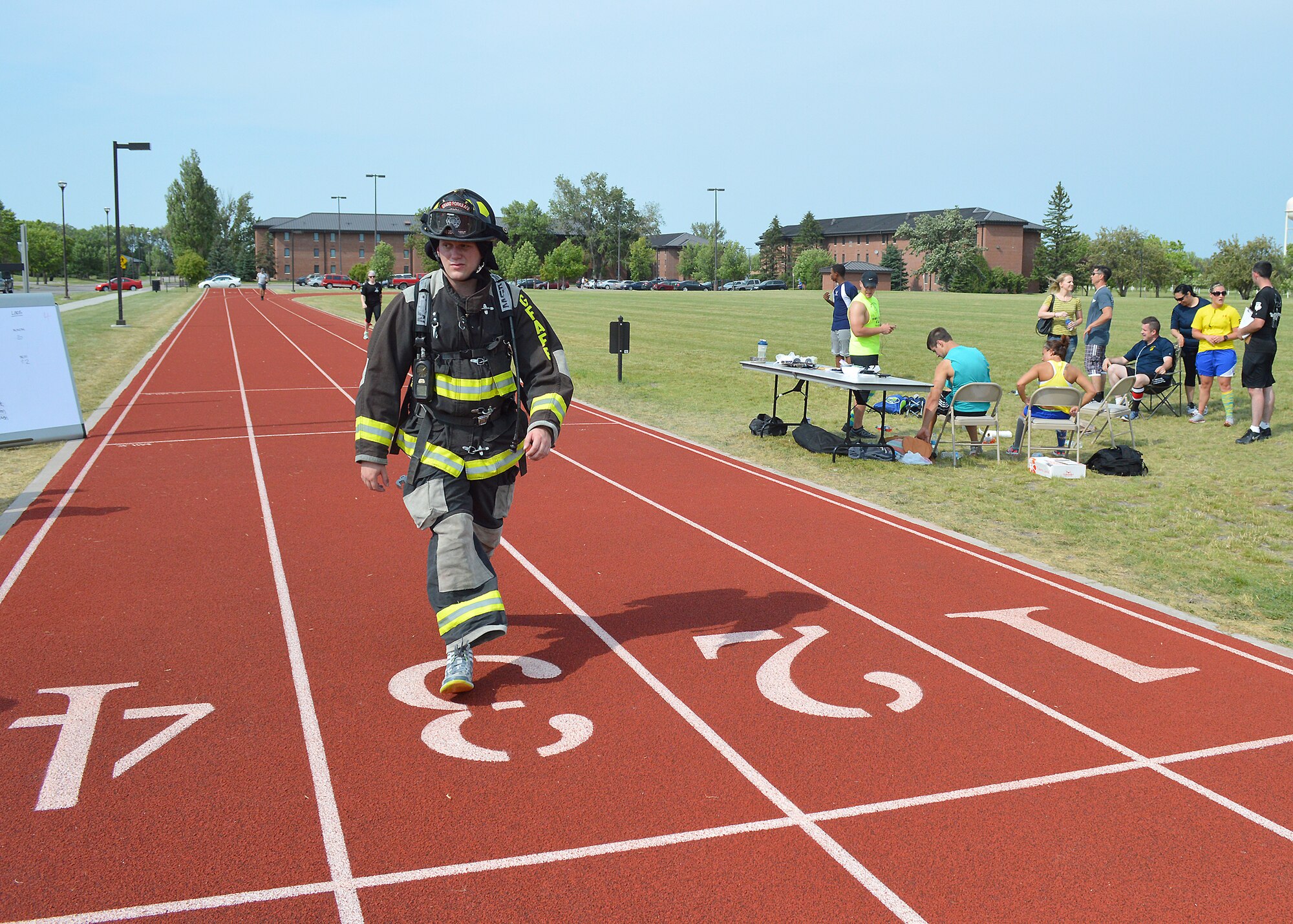 Airman Dustin Mog, 319th Civil Engineer Squadron firefighter, walks toward the line to start the next lap during the AFSA 12-Hour relay on July 18, 2014, on Grand Forks Air Force Base, N.D. The Grand Forks Firedogs team completed 45 laps around the base outdoor running track. The event was sponsored by the Air Force Sergeants’ Association, Chapter 964. (U.S. Air Force photo/Senior Airman Xavier Navarro)