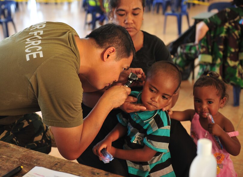 Philippines Air Force Maj. Darwin Farnacio, an ear, nose and throat physician, examines a patient during a healthcare services outreach, Neiafu, Vava'u, July 21, 2014. A makeshift clinic was set up in a local college auditorium with physical therapy, optometry, dental and family medicine clinics as well as a pharmacy. Farnacio is deployed from Manila, Philippines. (U.S. Air Force photo by Staff Sgt. Rachelle Coleman/Released)