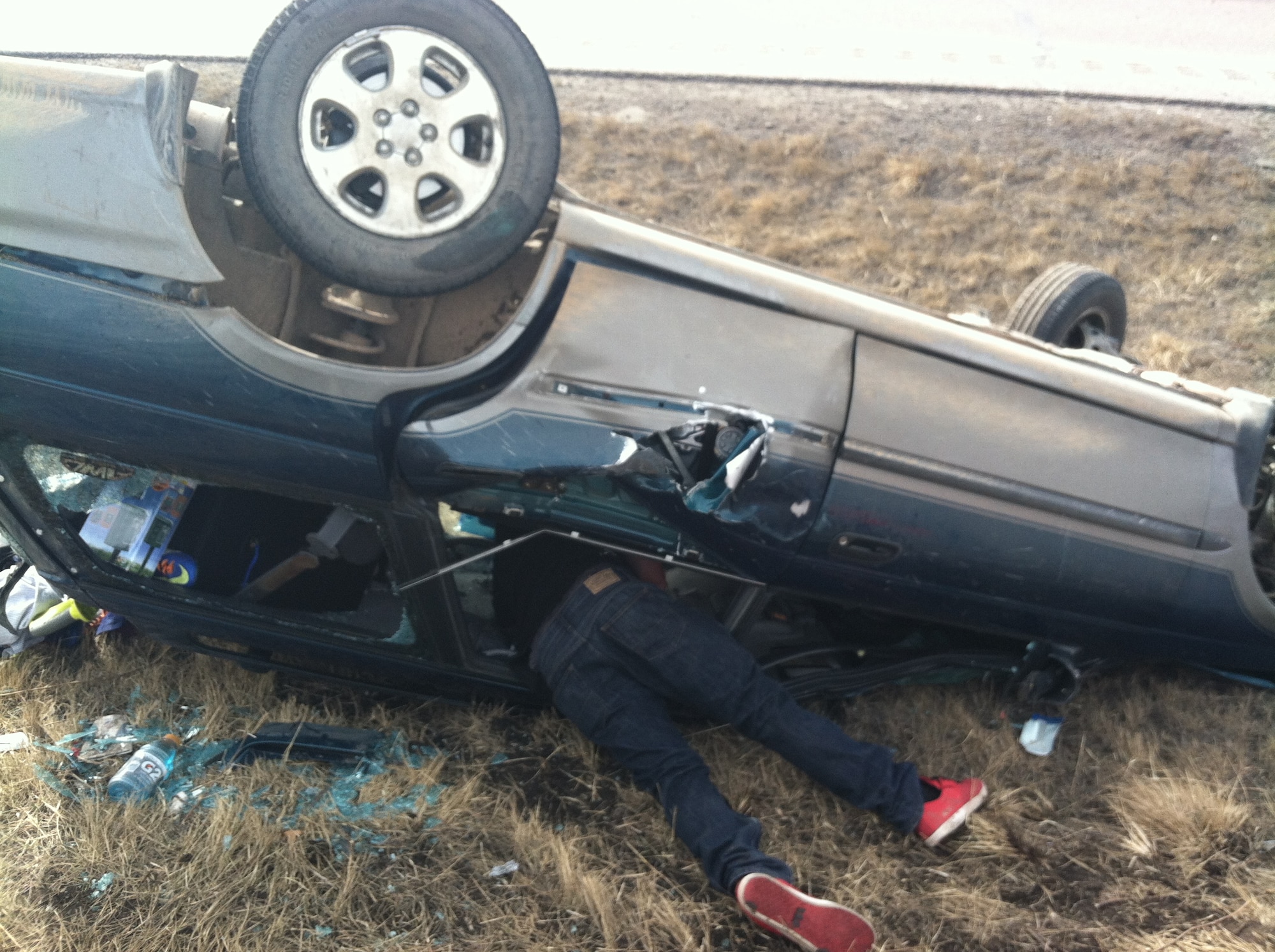 DOUGLAS COUNTY, Colo. – Capt. Robert Wray crawls through an overturned sport utility vehicle on I-25 between Monument and Castle Rock March 3, 2013. Wray and two others stopped on northbound I-25 to help remove three passengers after seeing smoke from the front of the vehicle. All three passengers lived. (Courtesy photo)