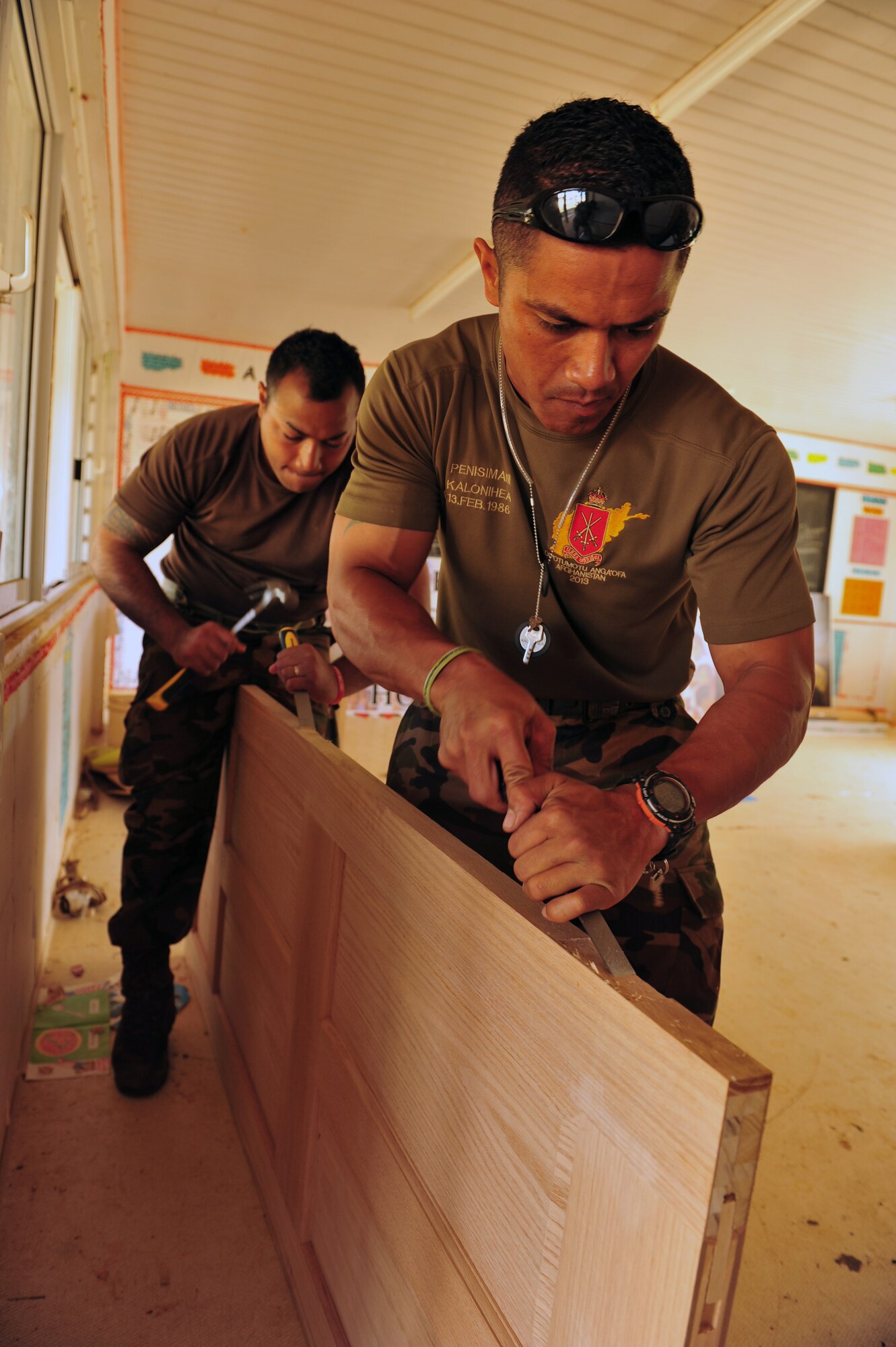His Majesty's Armed Forces Privates Benny Kalonihea and Muimui Toke, both carpenters, prepare to attach hinges to a door at Neiafu Government Primary School, Neiafu, Vava'u, July 17, 2014. Military electricians, structural craftsmen, carpenters and plumbers are working together to repair and replace doors, locks, windows, wiring, partitions, sinks, faucets, toilets and various additional requirements during the operation.Pacific Angel is a total force, joint and combined humanitarian assistance operation led by Pacific Air Forces. (U.S. Air Force photo by Staff Sgt. Rachelle Coleman)