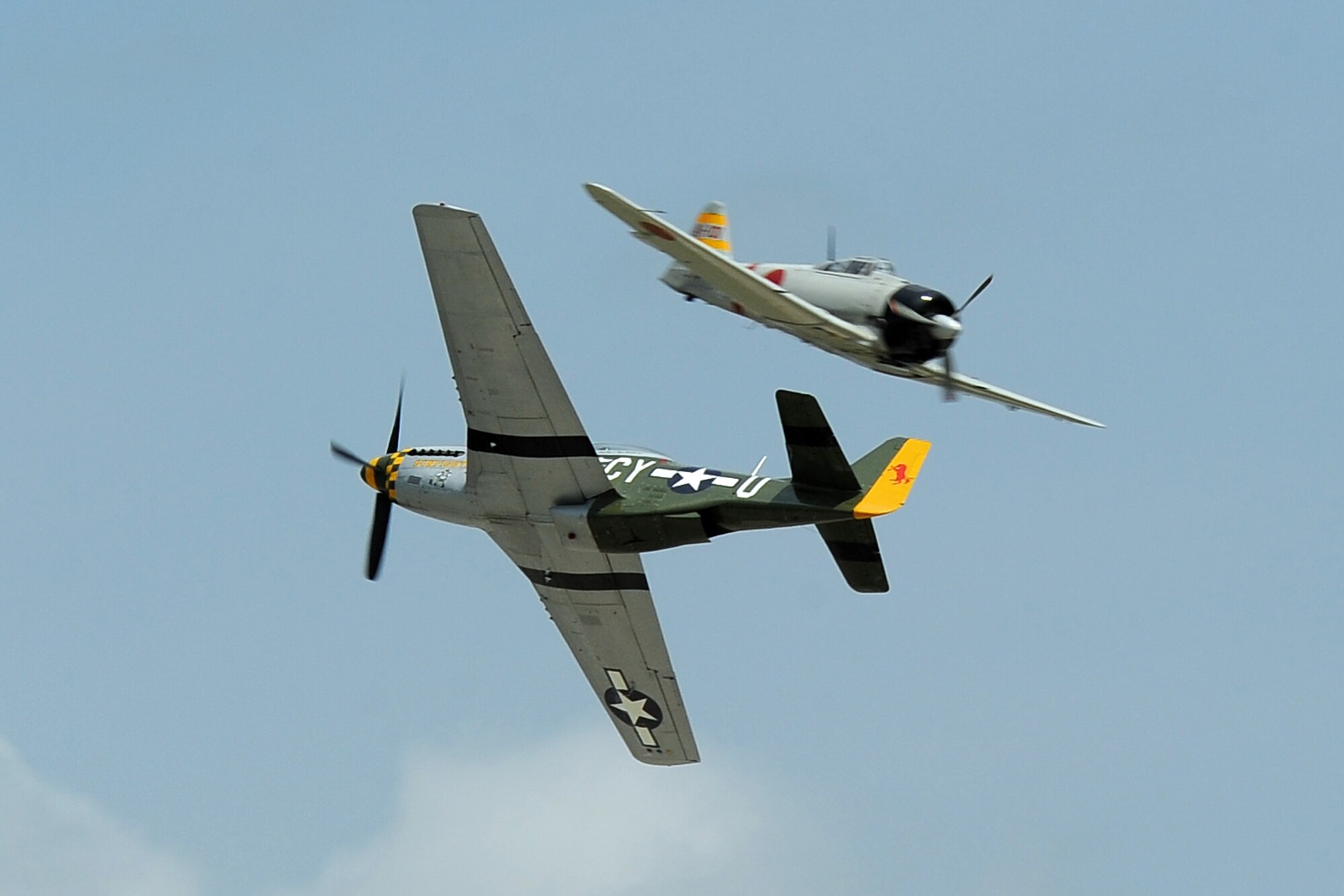 A P-51 Mustang performs a simulated dogfight with a Japanese Zero during the 2014 Defenders of Freedom Open House and Air Show held July 19 at Offutt Air Force Base, Nebraska.  The battle between the two vintage planes is one of several acts performed at the air show.  (U.S. Air Force photo by Josh Plueger/Released)