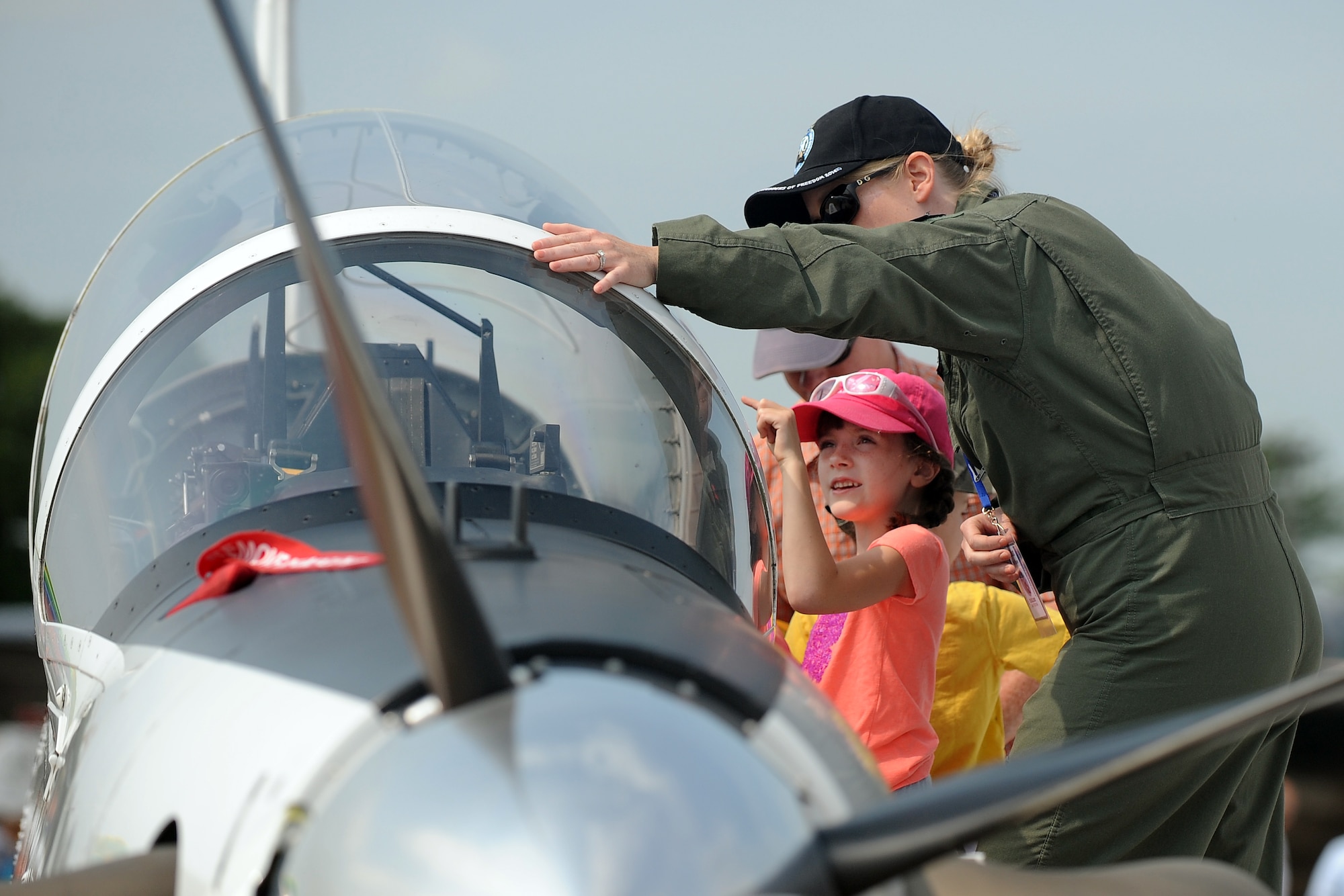 Seven-year-old Naomi Roth, daughter of U.S. Air Force Maj. Jeremy Roth, 45th Reconnaissance Squadron, peers into the cockpit of a T-6 with U.S. Air Force Capt. Jami Gunnels, T-6 instructor pilot, while attending the 2014 Open House and Air Show July 19 at Offutt Air Force Base, Nebraska. (U.S. Air Force photo by Josh Plueger/Released)