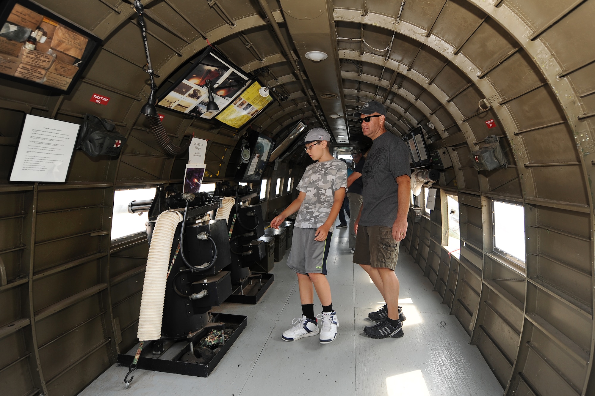 Scott Thomas along with his son Evan walk inside the AC-47 Gun Ship while attending the 2014 Defenders of Freedom Open House and Air Show July 19 at Offutt Air Force Base, Nebraska.  The AC-47 nicknamed “Spooky” was one of several vintage aircraft on the Offutt ramp.  (U.S. Air Force photo by Josh Plueger/Released)