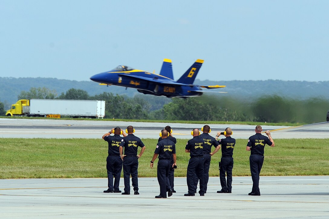 The U.S. Navy crew chiefs cheer on their U.S. Navy Blue Angels pilots as they launch from the Offutt Air Force Base, Nebraska runway at the 2014 Defenders of Freedom Open House and Air Show July 19.  The U.S. Navy Blue Angels performed for two days at Offutt to the delight of nearly two hundred thousand attendees.  (U.S. Air Force photo by Josh Plueger/Released)