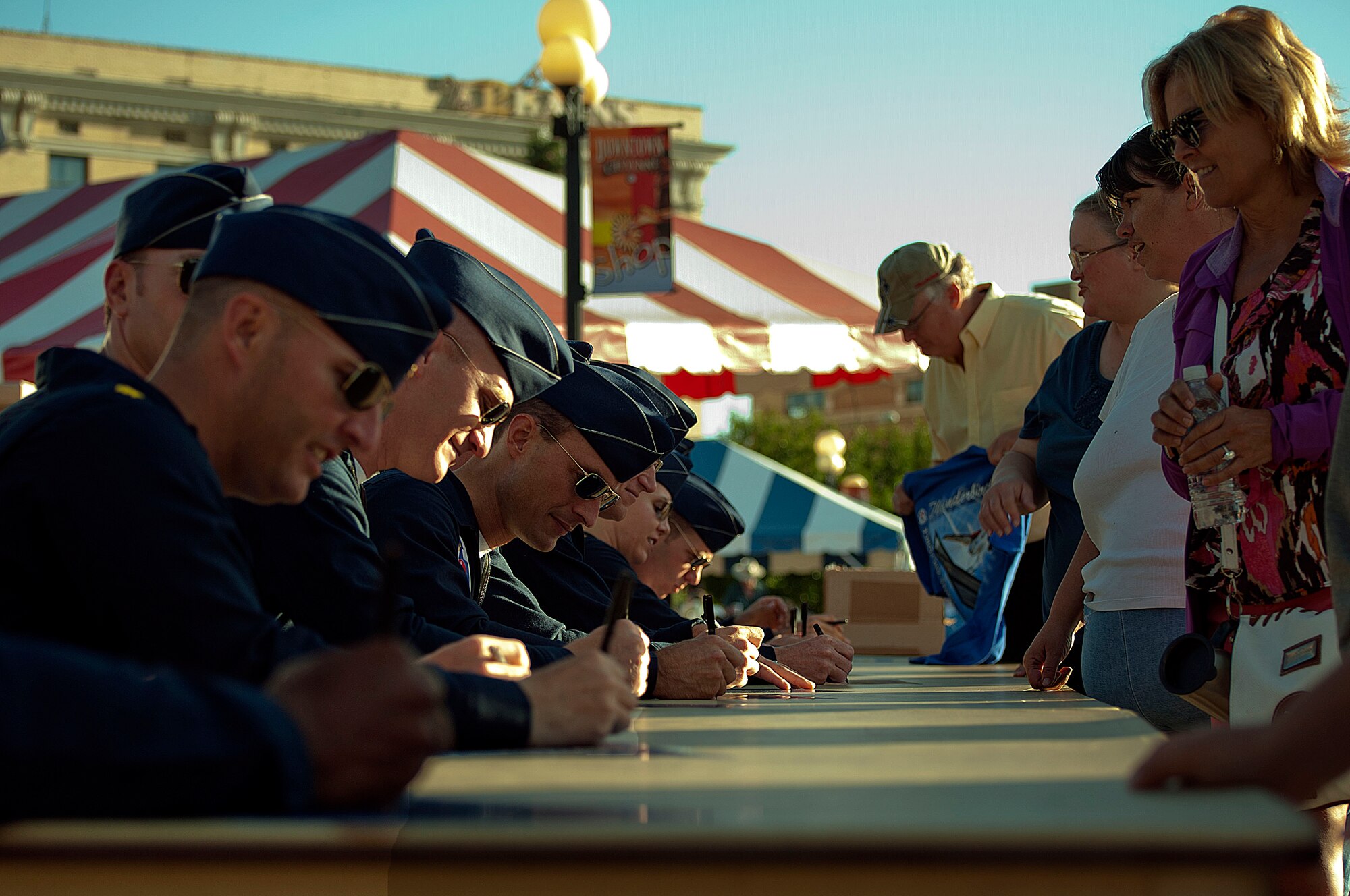 The U.S. Air Force Thunderbirds sign autographs July 21 for members of the Cheyenne community and visitors for Cheyenne Frontier Days during the annual pancake breakfast at the Cheyenne Depot Plaza. The Thunderbirds use community outreach events, such as the breakfast, to accomplish three missions: recruit, represent and retain. (U.S. Air Force photo by Airman 1st Class Brandon Valle)