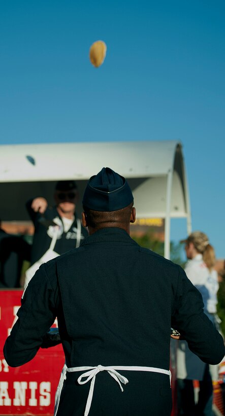 Maj. Darrick Lee, U.S. Air Force Thunderbirds Public Affairs officer, prepares to catch a flipped pancake from Maj. Michael Fisher, U.S. Air Force Thunderbirds pilot, July 21 during a pancake breakfast held in the Cheyenne Depot Plaza. The traditional pancake flip and catch is a spectator sport for those waiting in line for the breakfast. (U.S. Air Force photo by Airman 1st Class Brandon Valle)