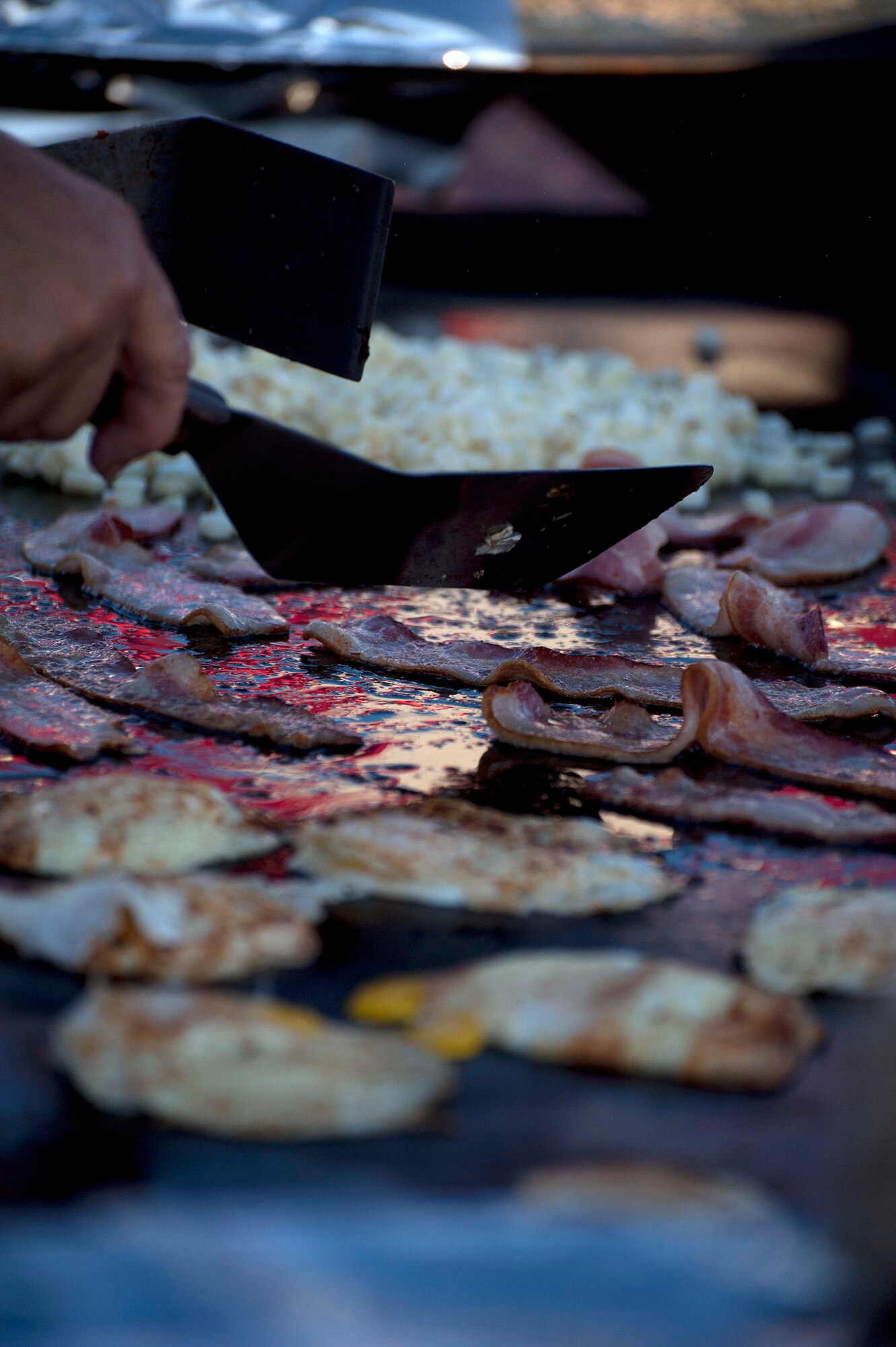 Bacon, eggs and potatoes cook on a large skillet grill July 21 during the annual pancake breakfast at the Cheyenne Depot Plaza. Approximately 10,000 people showed up for the breakfast. (U.S. Air Force photo by Airman 1st Class Brandon Valle)