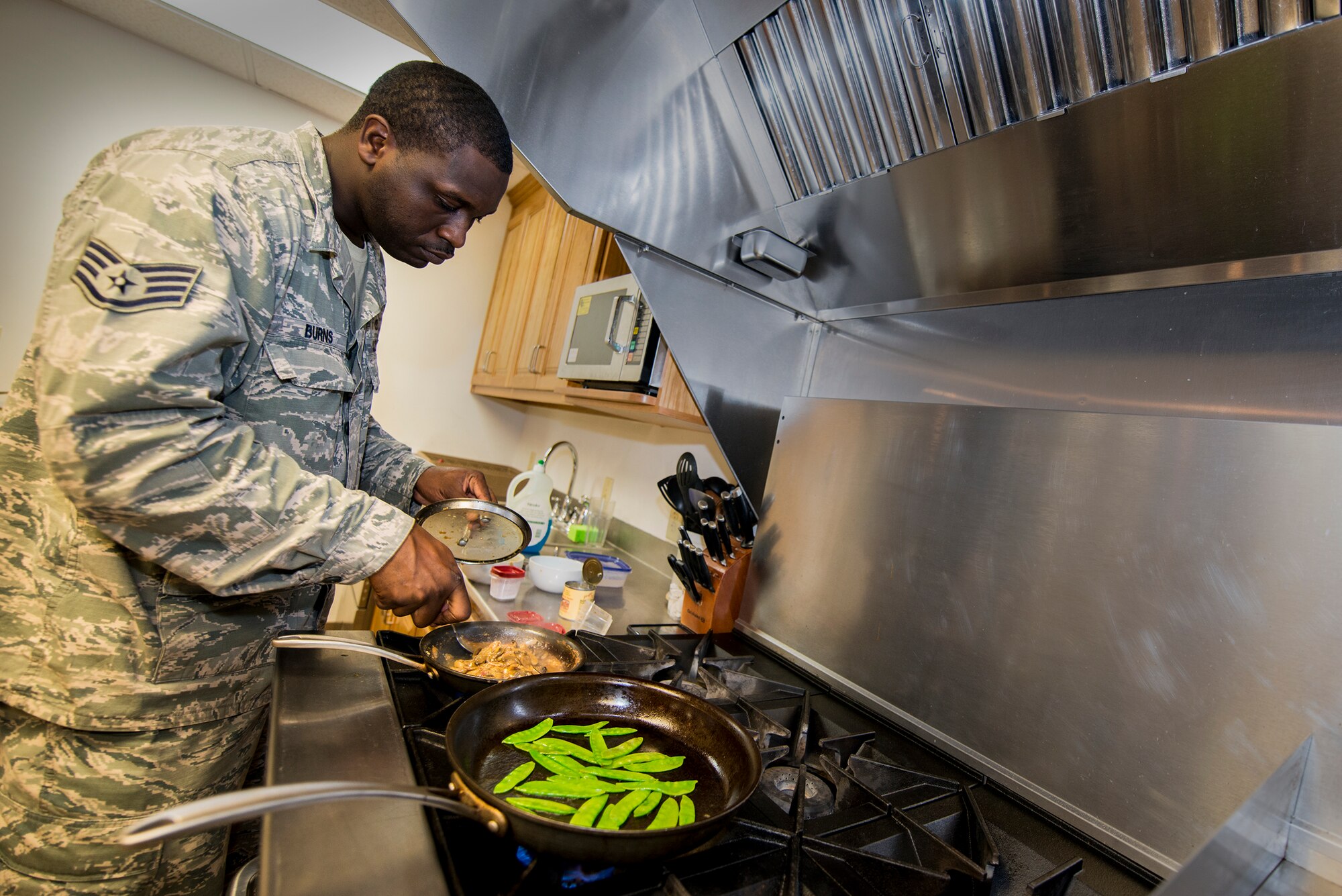 U.S. Air Force Staff Sgt. Phillip Burns II, 23d Civil Engineer Squadron fire inspector, prepares monterey chicken at Moody Air Force Base, Ga., July 17, 2014. Burns garnished his plate with sweet peas and mushroom sauce. (U.S. Air Force photo by Airman 1st Class Ryan Callaghan/Released)
