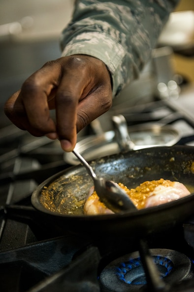 U.S. Air Force Staff Sgt. Phillip Burns II, 23d Civil Engineer Squadron fire inspector, prepares monterey chicken at Moody Air Force Base, Ga., July 17, 2014. Burns has been cooking for 15 years and says his love of cooking started in the firehouse. (U.S. Air Force photo by Airman 1st Class Ryan Callaghan/Released)