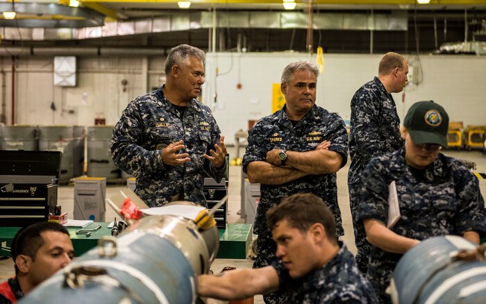 Cmdr. Charles Phillip, Naval Munitions Command commander (left), and Capt. Timothy Sparks, Joint Base Charleston deputy commander, observe NMC minemen as they conduct an exercise in the Navy Munitions Command mine shop, July 16, 2014, at JB Charleston, S.C. The Sailors in the mine shop routinely conduct drills and exercises to maintain their qualifications so they will be ready to deploy if necessary. (U.S. Air Force photo by Senior Airman Dennis Sloan)