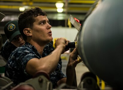 Petty Officer 2nd Class Daniel Bentley, Navy Munitions Command mineman, works on mines during an exercise July 16, 2014, at Joint Base Charleston, S.C. The Sailors in the mine shop routinely conduct drills and exercises to maintain their qualifications so they will be ready to deploy if necessary.  (U.S. Air Force photo by Senior Airman Dennis Sloan)