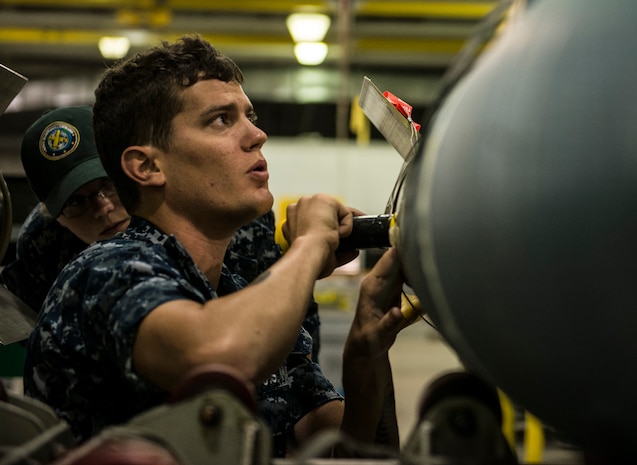 Petty Officer 2nd Class Daniel Bentley, Navy Munitions Command mineman, works on mines during an exercise July 16, 2014, at Joint Base Charleston, S.C. The Sailors in the mine shop routinely conduct drills and exercises to maintain their qualifications so they will be ready to deploy if necessary.  (U.S. Air Force photo by Senior Airman Dennis Sloan)